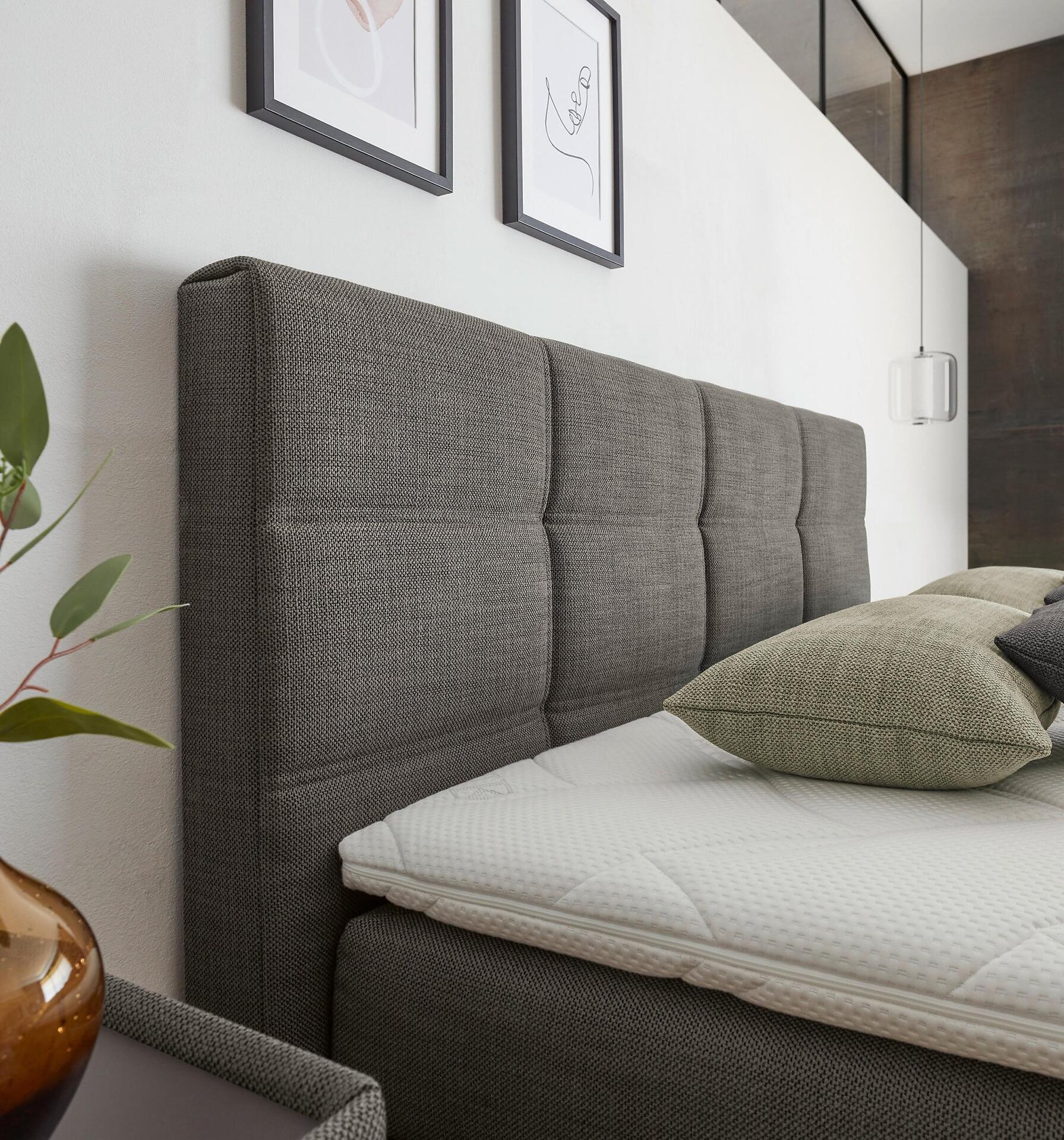 Schlafsofa Luxor Line BX mit grauem Kopfteil und Rechtecksteppung, das die Funktion als Schlafsofa verdeutlicht.