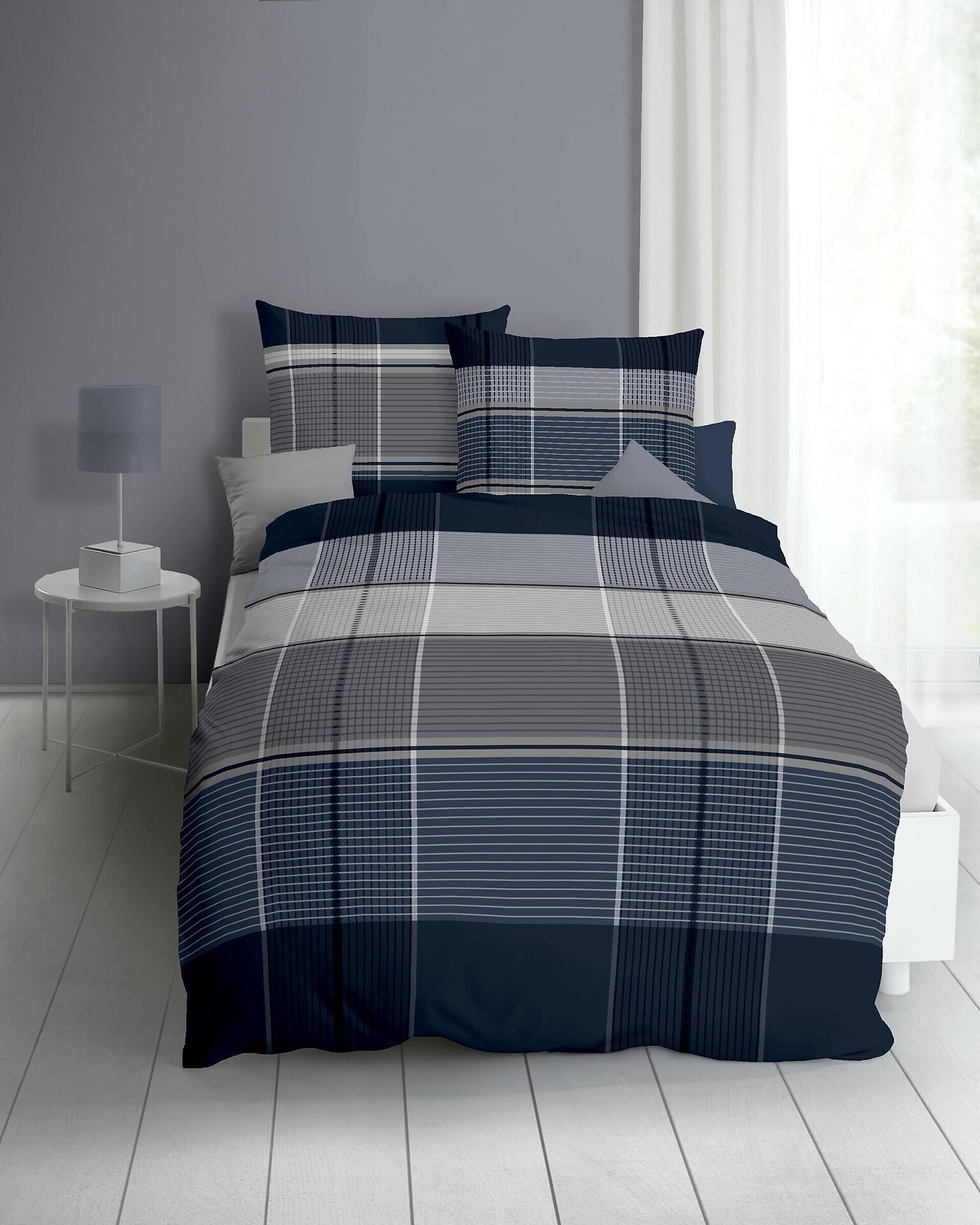 Blau-graue Bettwäsche mit Karomuster im Detailansicht, bestehend aus Bettdecke und zwei Kissen (80x80 cm) auf einem Bett.
