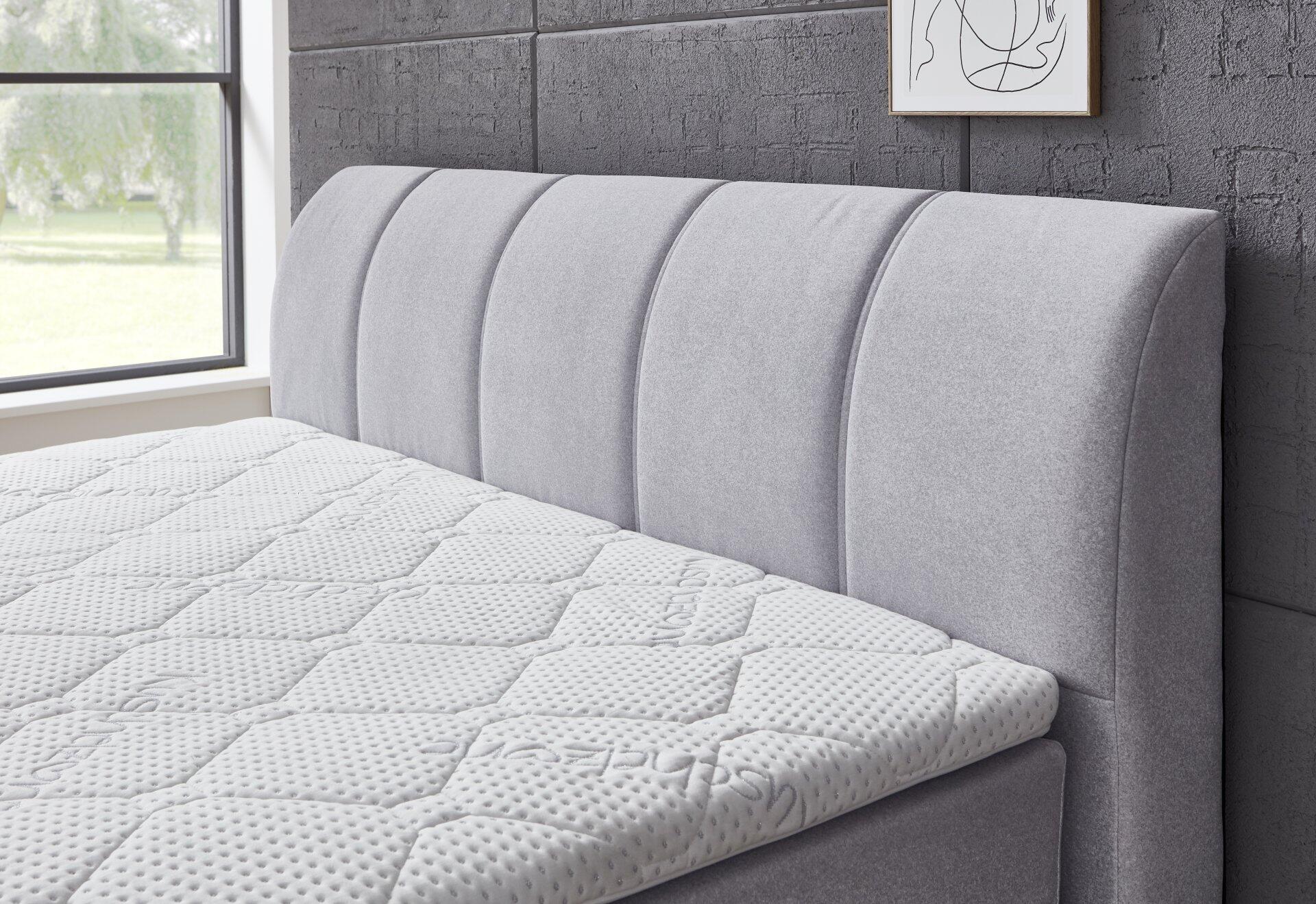 Boxspringbett Graz BX2630 mit grauem, hoch gepolsterten Kopfteil und strukturierter Oberfläche.
