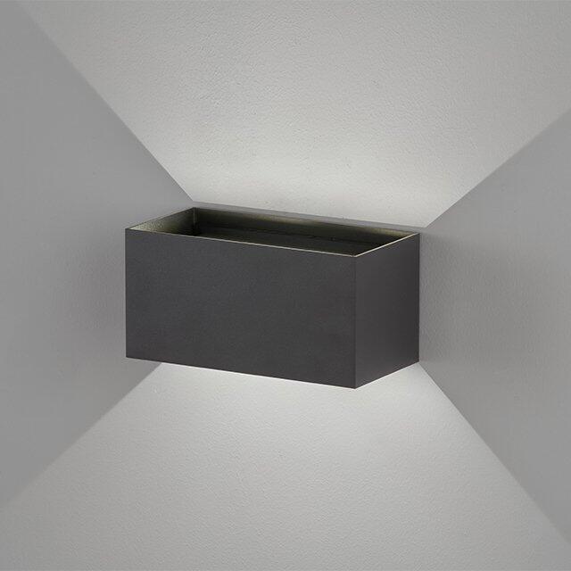 Wallo Wandleuchte, dunkelgrau, rechteckiges Design mit indirekter Beleuchtung, die ein geometrisches Lichtmuster auf der weißen Wand erzeugt.