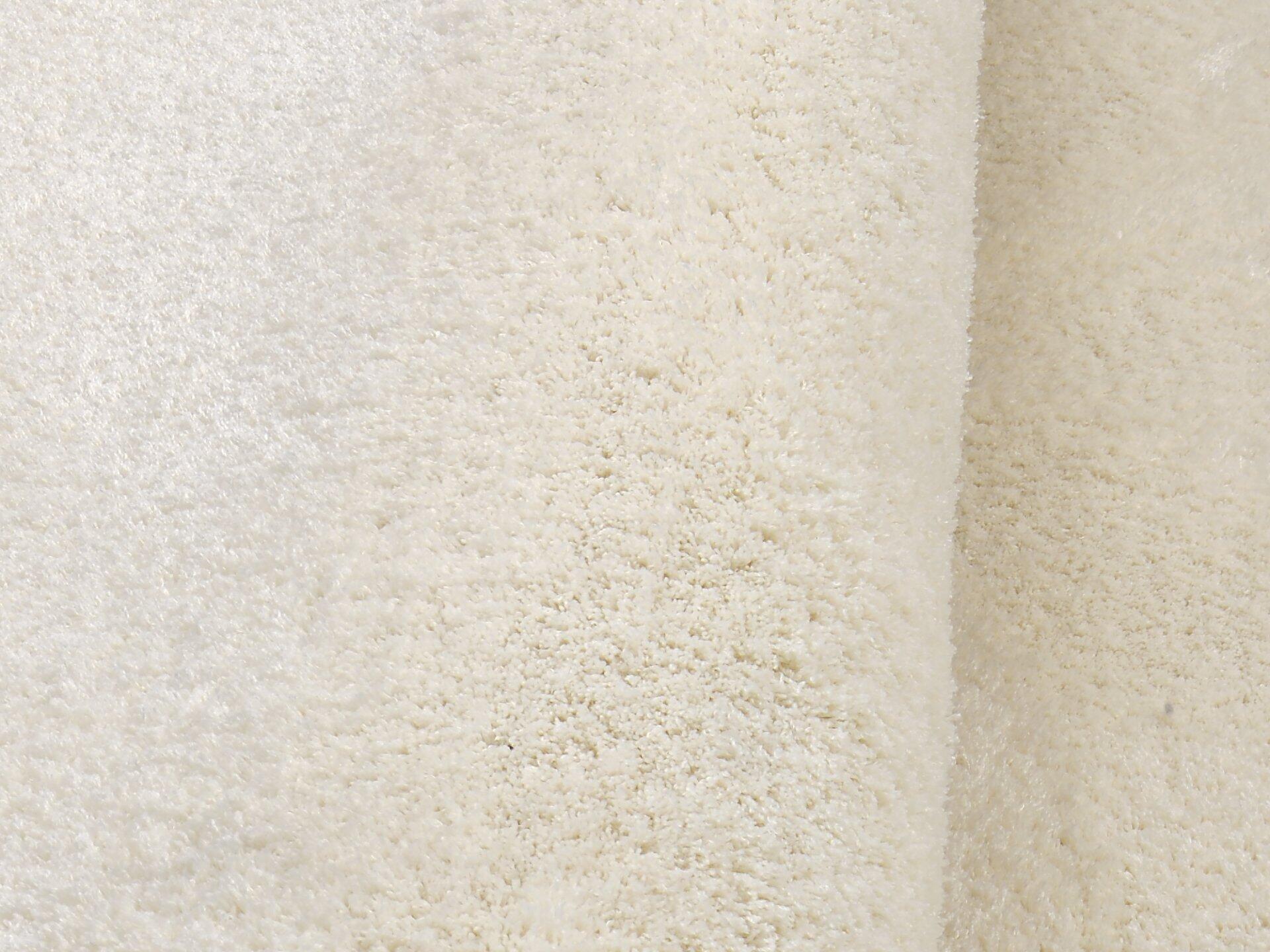 Nahaufnahme eines cremefarbenen, flauschigen Teppichs mit einer Florhöhe von 30 cm, die die dichte Textur und die gleichmäßigen Fasern des Maschinenwebteppichs Mardin zeigt.