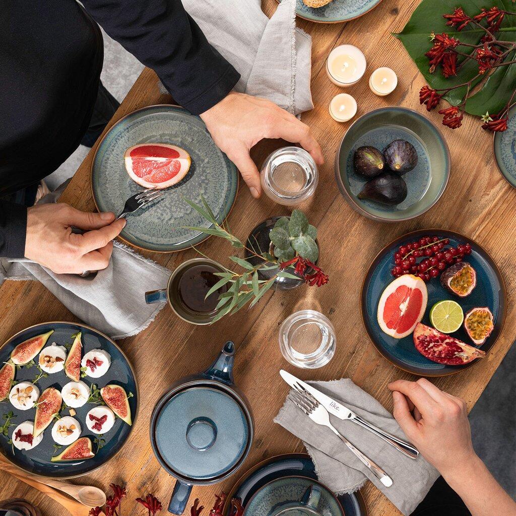 Bowl Crafted Breeze aus Reaktivglasur, zentral platziert auf einem gedeckten Tisch, umgeben von Lebensmitteln und Besteck, in einer gemütlichen Esssituation.