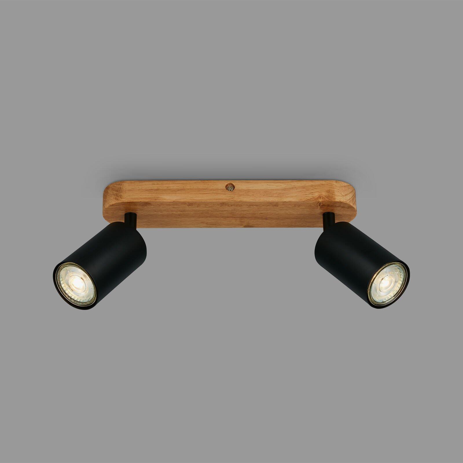 Wandleuchte Spot Kullig mit zwei GU10-Lampen, die an einem rustikalen Holzträger befestigt sind und einen hellen Lichtschein abgeben.