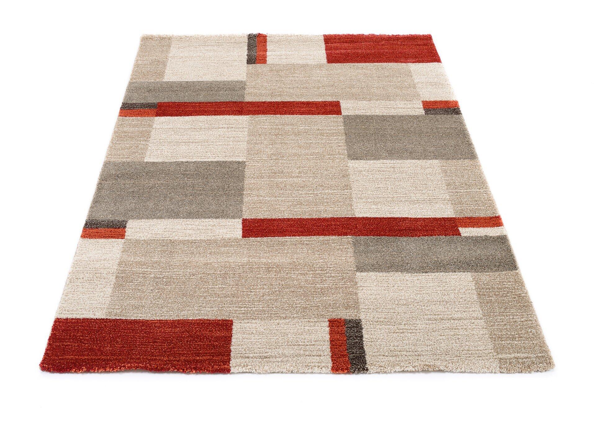 Maschinenwebteppich Salda mit geometrischem Muster aus hellen und dunklen Rechtecken in Beige, Grau und Rotbraun, aus schräger Perspektive fotografiert.