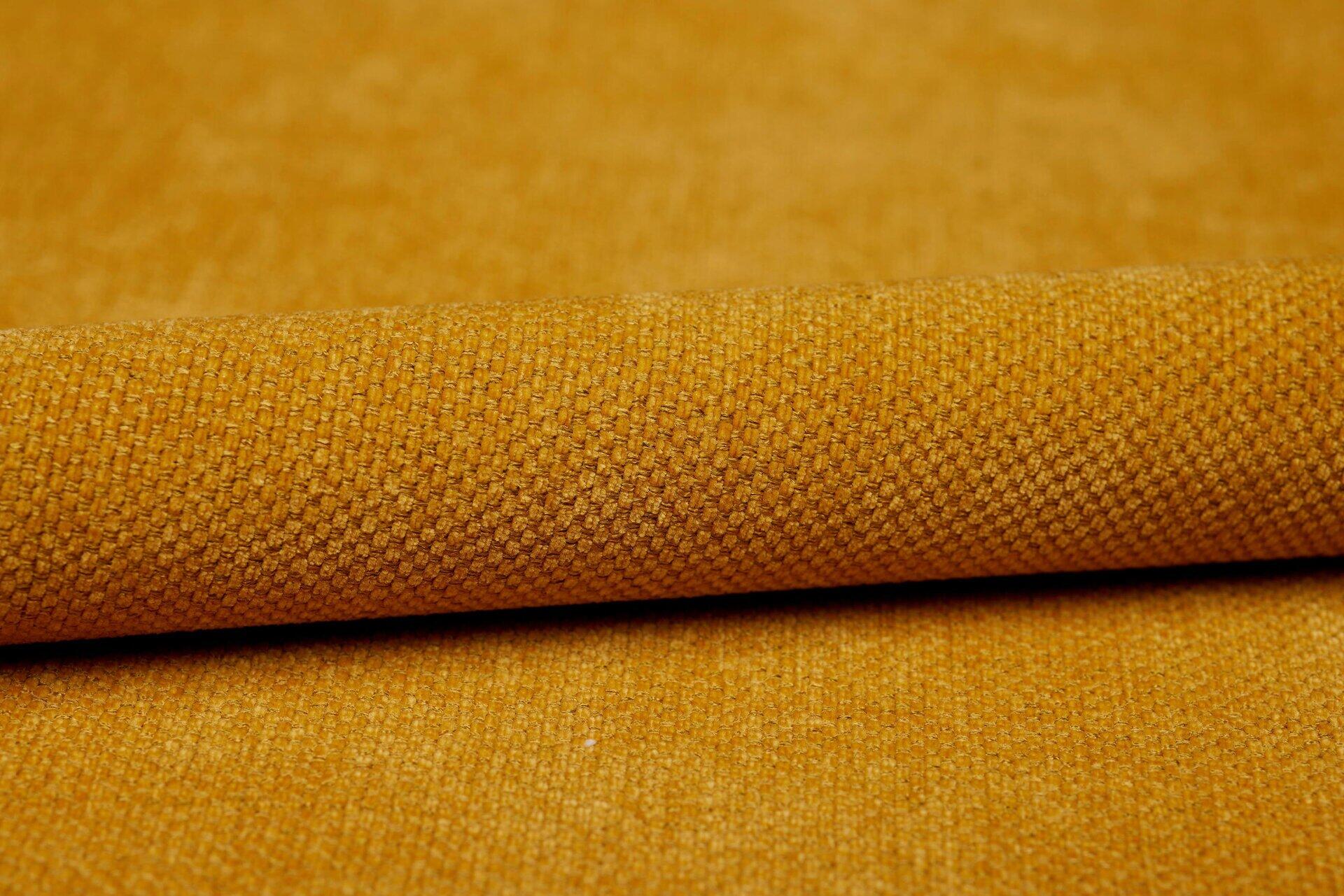 Detailaufnahme des robusten, gelben Stoffbezugs für das Ecksofa Tokyo, der die Textur und Fallhöhe des Materials zeigt.