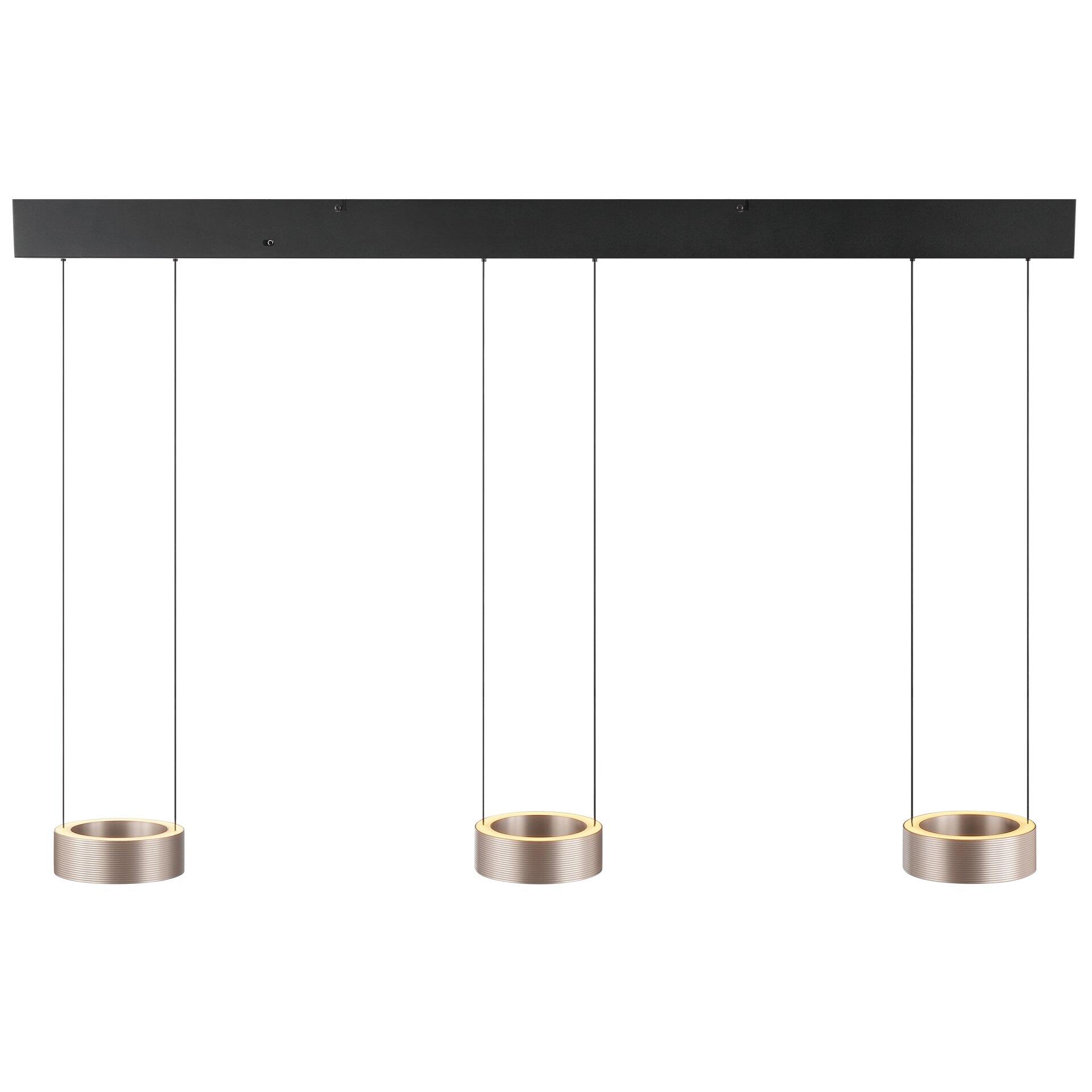 Drei goldfarbene Pendelleuchten der Axion-Serie hängen in einer Reihe an einer schwarzen Deckenplatte, wobei die minimalistische Designsprache mit metallenen Ringen und weißen Kabeln zur Geltung kommt.