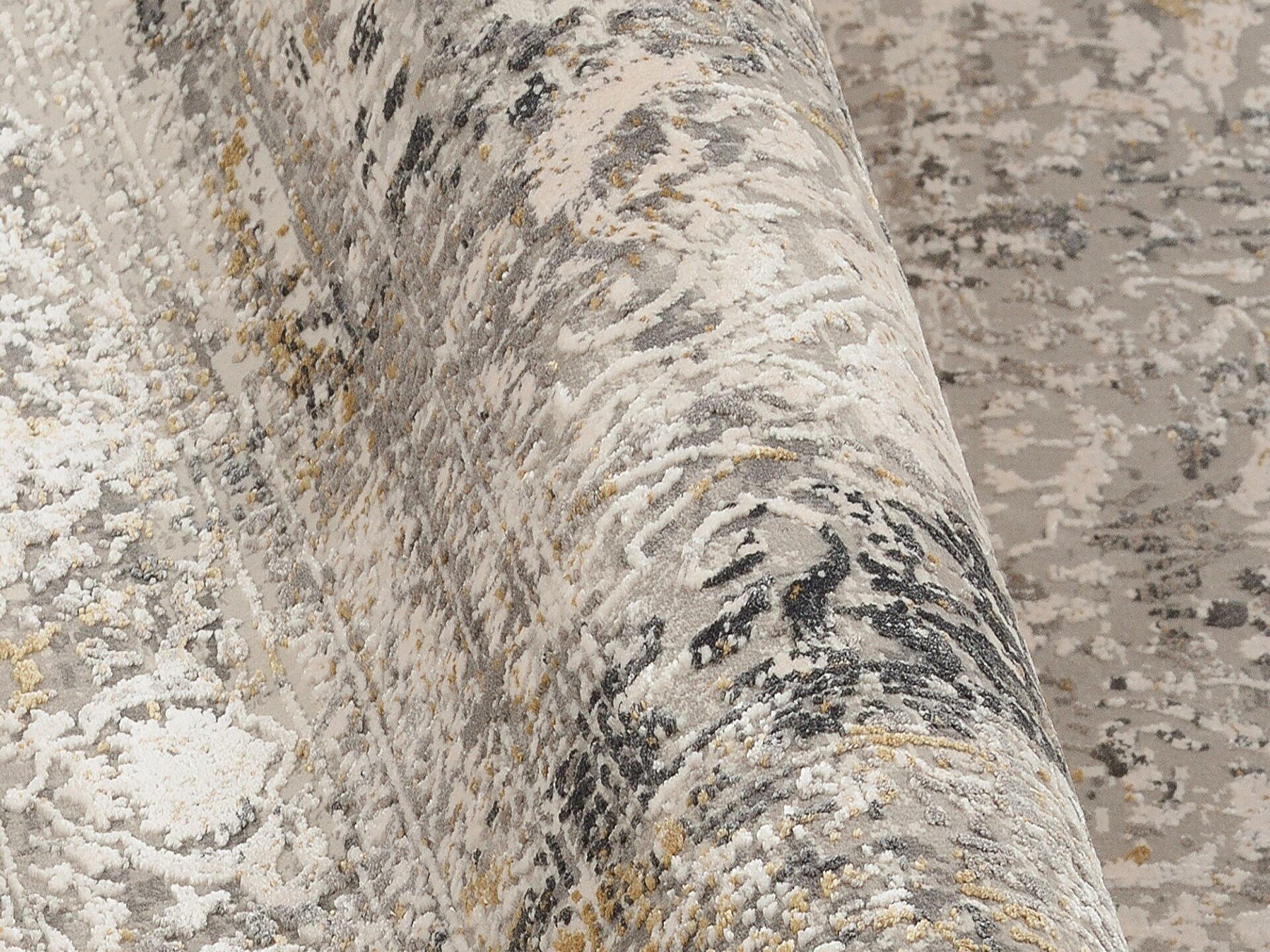 Detailaufnahme des Maschinenwebteppichs Amasya mit strukturiertem, gemustertem Design in Beige, Grau und Gelb, das eine raue, haptische Textur zeigt.