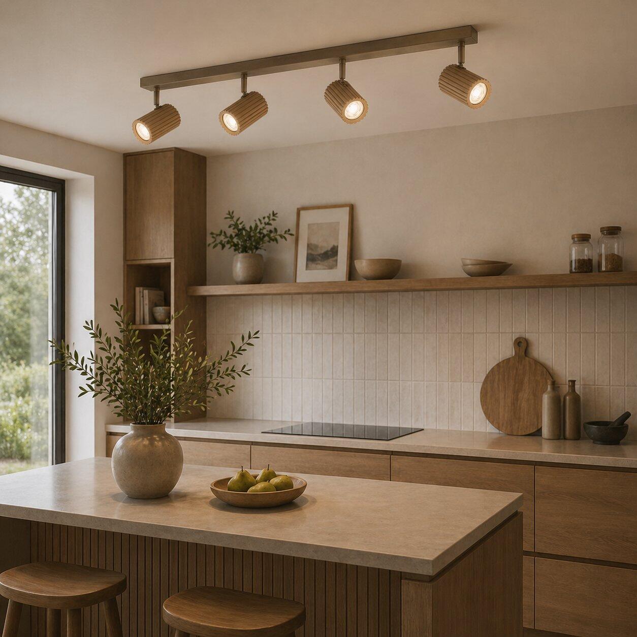 Deckenleuchte Lakewood mit drei schwenkbaren, goldenfarbenen Lampen über einer Kücheninsel.