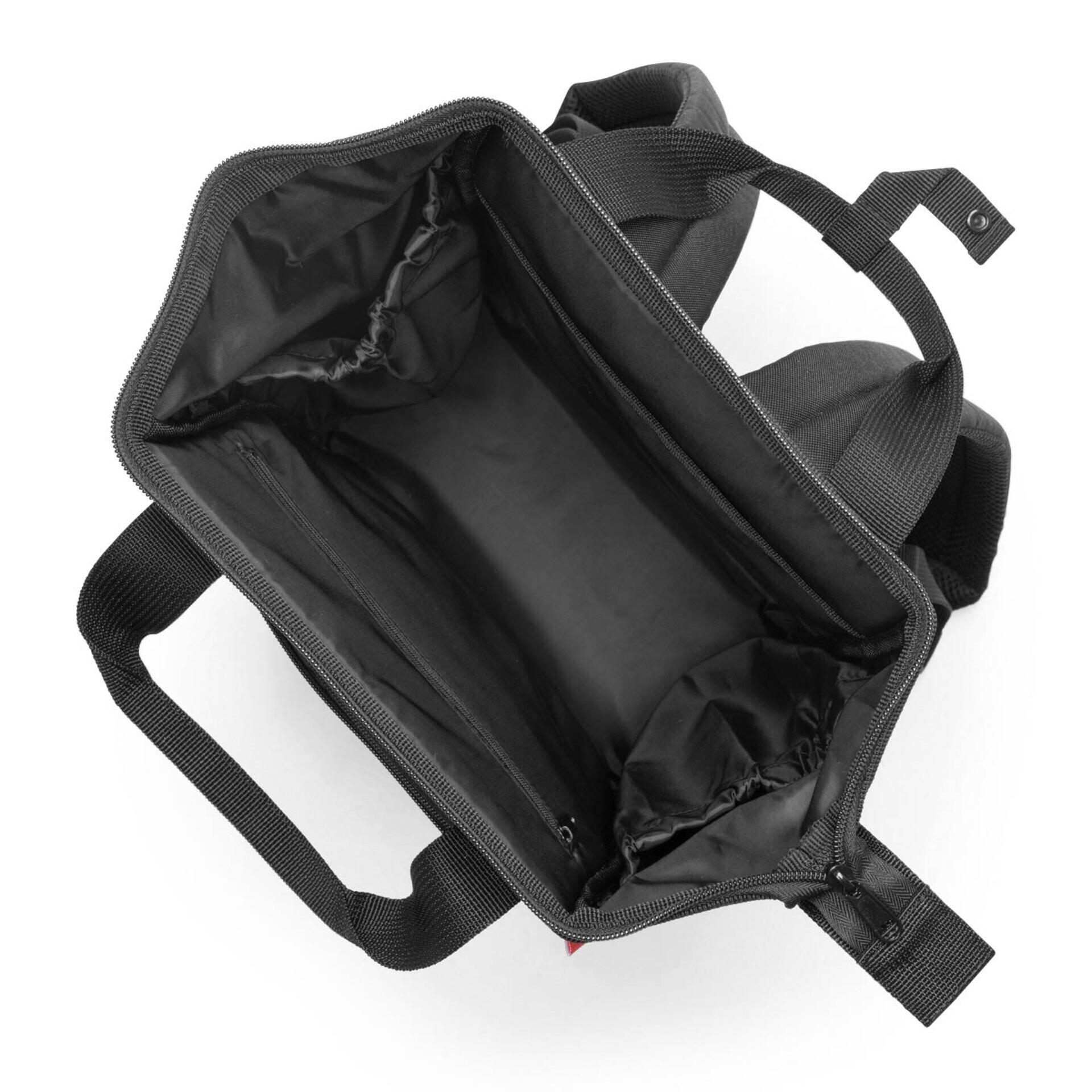 Nahaufnahme der geöffneten schwarzen Werkzeugtasche Allrounder r mit dunkelrotem Innenfutter, mehreren Reißverschluss-Innenfächern und verstärkten Tragegriffen.