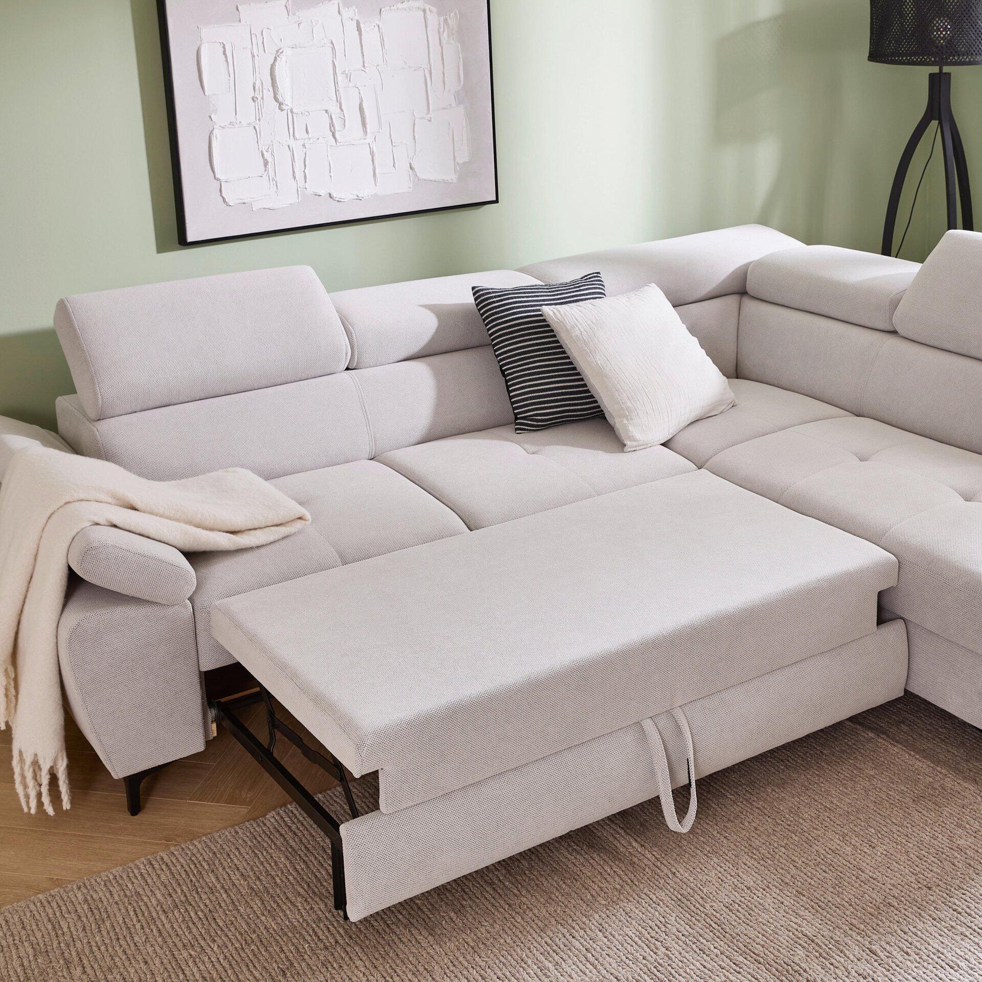 Ecksofa Combo mit abklappbarer Kopfstütze und ausziehbarer Liegefläche, dargestellt aus einer leicht seitlichen Perspektive auf grauem Stoff mit schwarzen Metallfüßen.