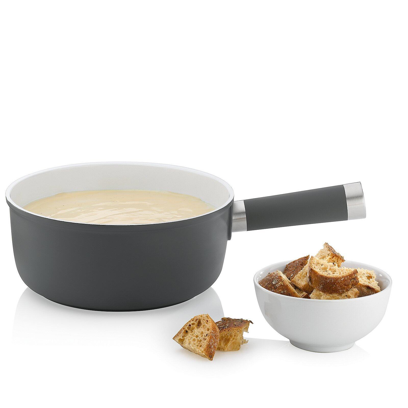 Käsefondue-Set Lancy: Graues Kochgefäß mit weißem Innenraum und Griff, daneben eine Schale mit gerösteten Brotwürfeln.