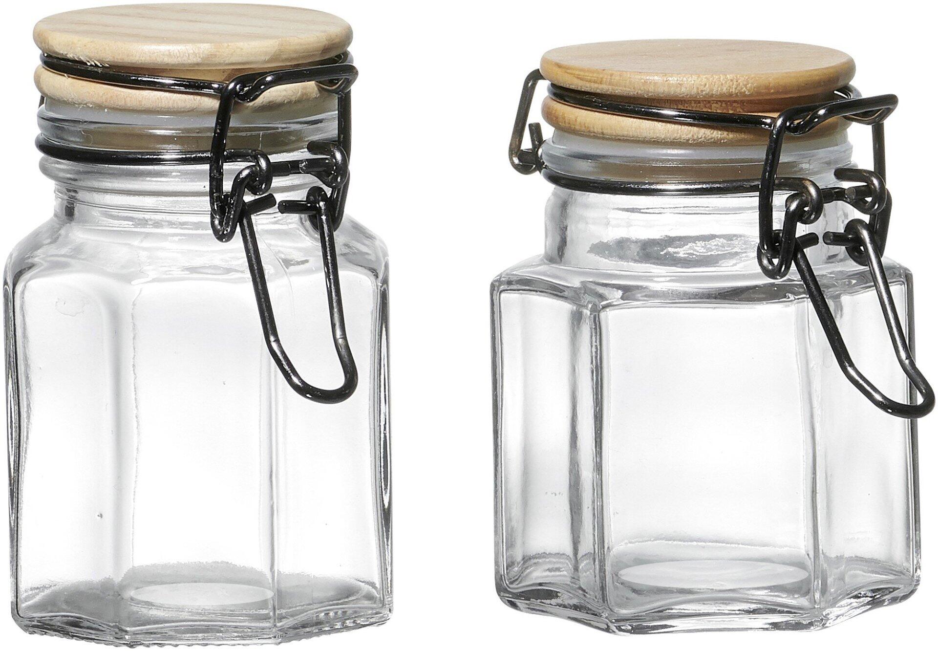 Vorratsglas Esperanza: Zwei sechseckige Gläser mit Holzböden und Metallverschlüssen, frontal und leicht von unten fotografiert.