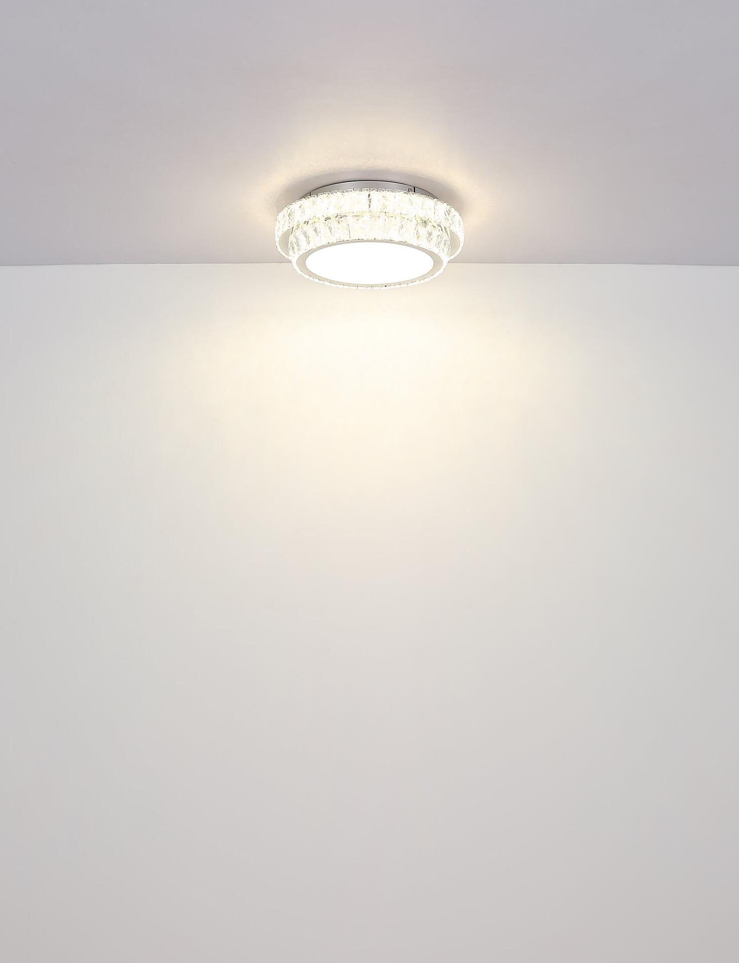 Deckenleuchte KLARA mit silbernem Metallrahmen und Kristallapplikationen, dargestellt aus der Vogelperspektive, zeigt die gleichmäßige Lichtverteilung und das Design.