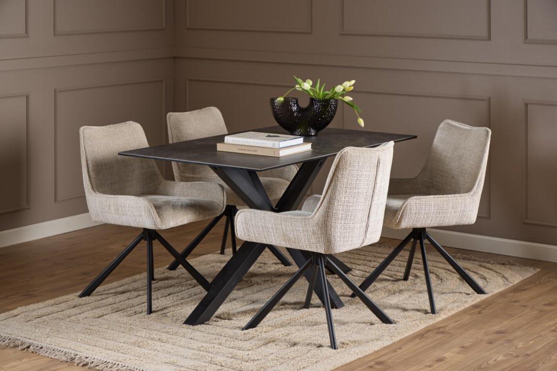 Esszimmer mit quadratischem Esstisch Heaven, schwarze Tischplatte auf schräg gestelltem Metallgestell, vier Stühle mit Stoffbezug und auffälligem Design.