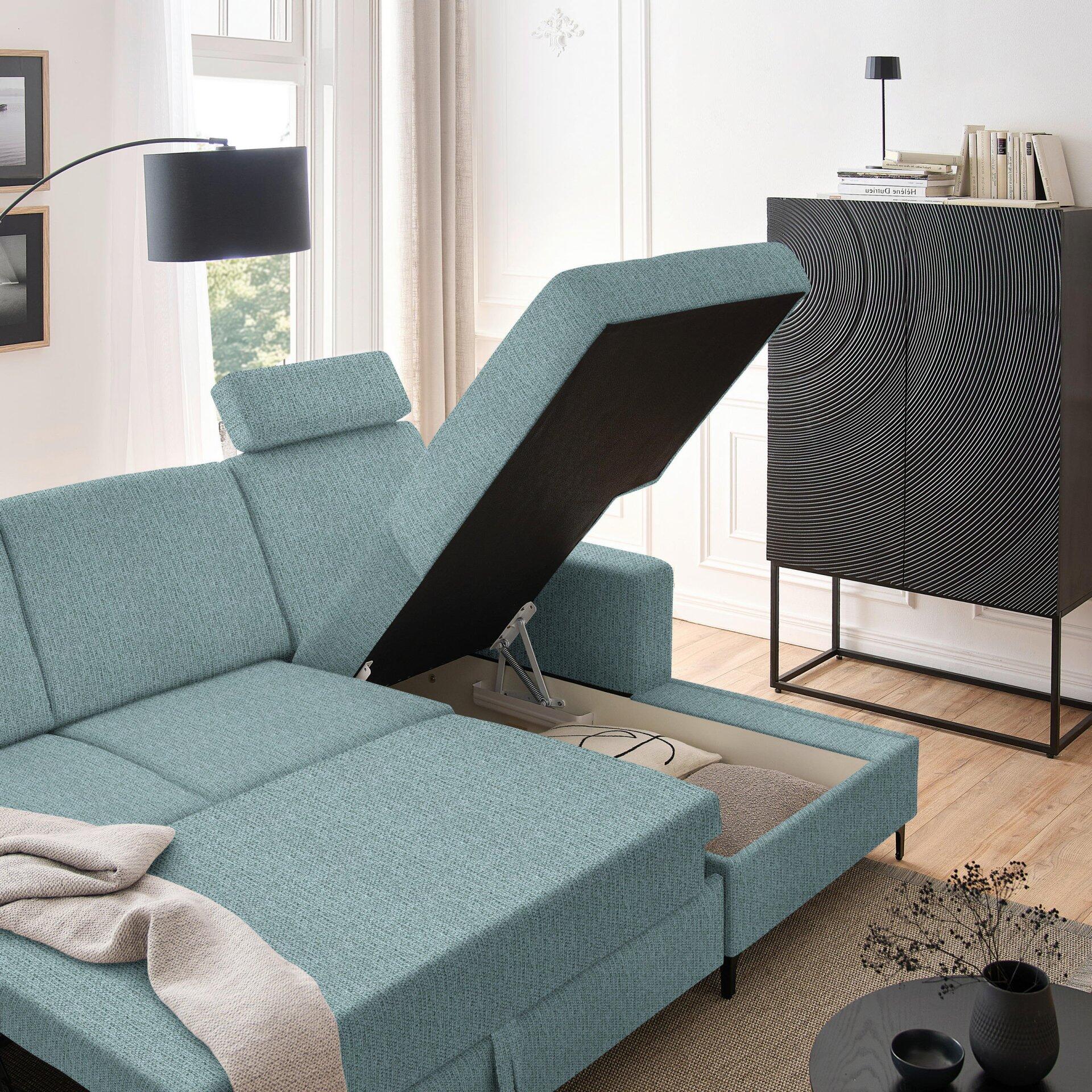 Blaues Ecksofa Balina mit geöffneter Rückenlehne, die die Mechanik für die Schlaffunktion zeigt, auf einer erhöhten Perspektive im Wohnzimmer.