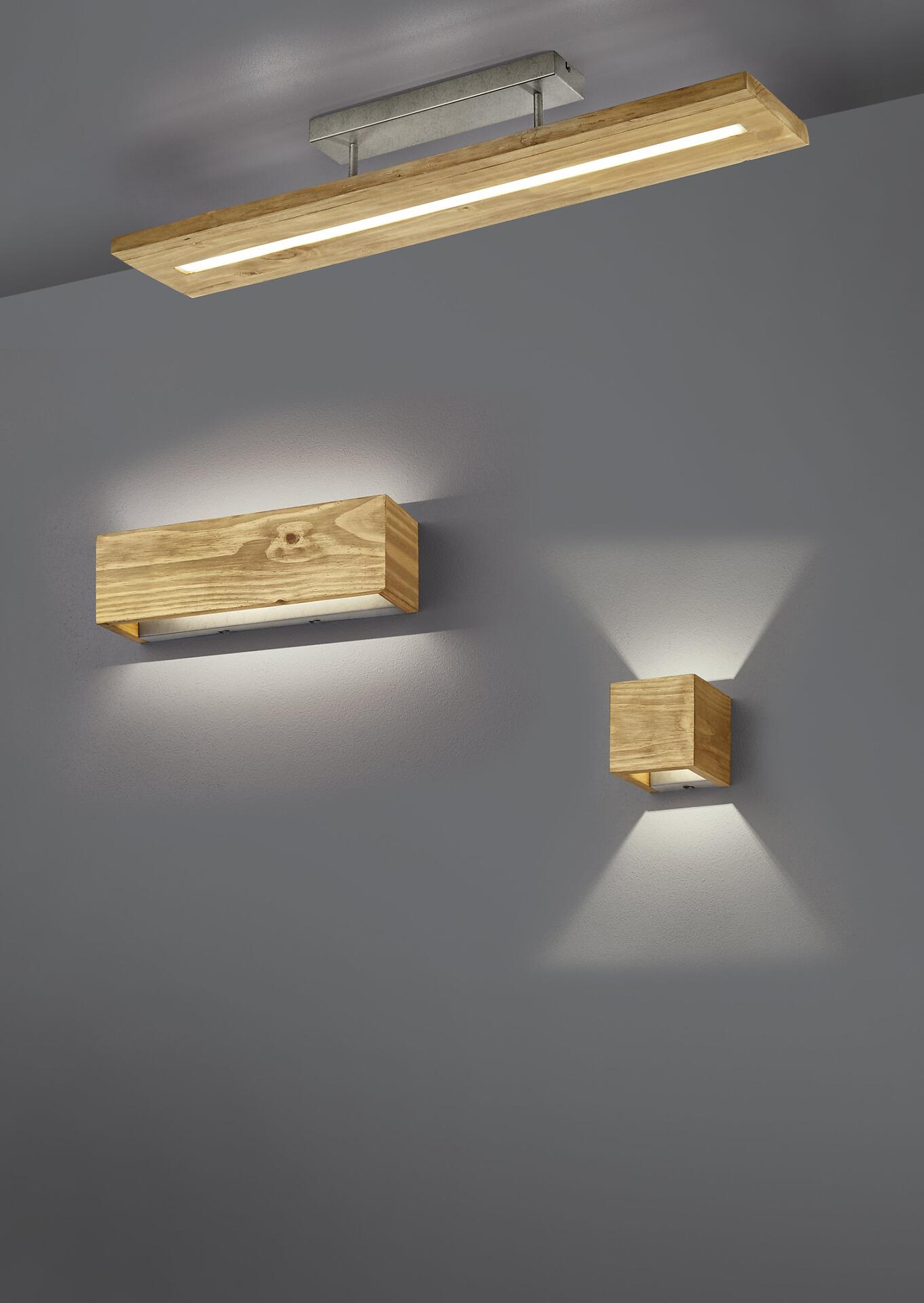 Wandleuchte Brad aus Holz, seitlich an der Wand angebracht, mit gerichteter LED-Beleuchtung, die einen Lichtschein auf die Wand darunter wirft.