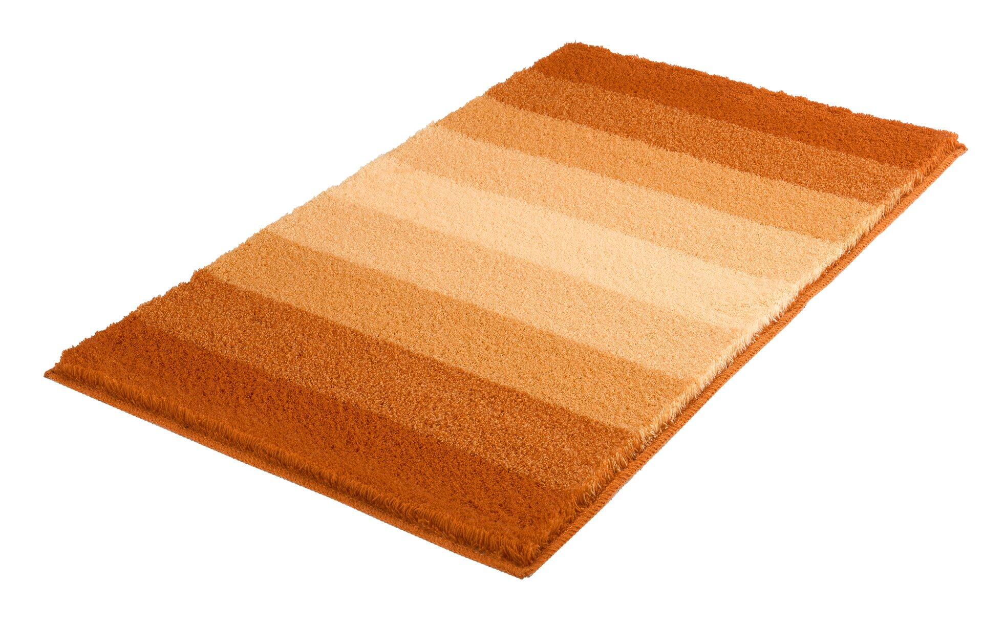 Badteppich Palace mit flauschigem Flor und diagonalem Farbverlauf von Beige zu Orange, aus der Vogelperspektive sichtbar.
