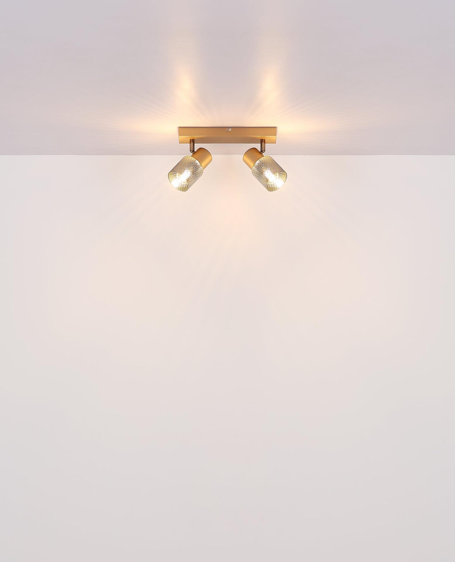 Wandleuchte SATELLA mit rechteckigem goldenem Gehäuse, zwei Bernsteingläsern und warmen Lichtflecken.