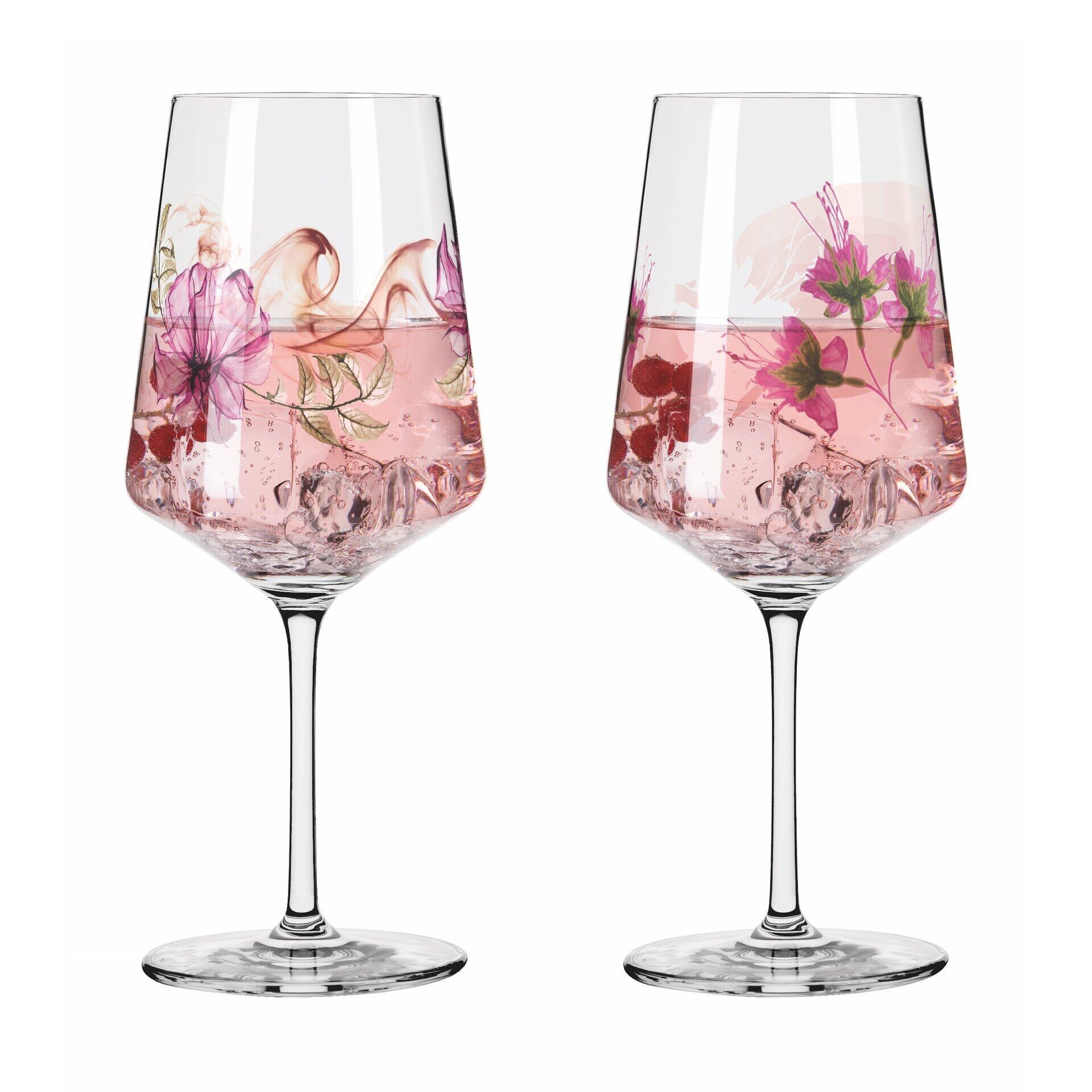Aperitifglas-Set mit zwei Gläsern, die aus der Vogelperspektive im schrägen Winkel mit pinkfarbenem Getränk, Blütenblättern und Himbeeren im Kelch dargestellt sind.