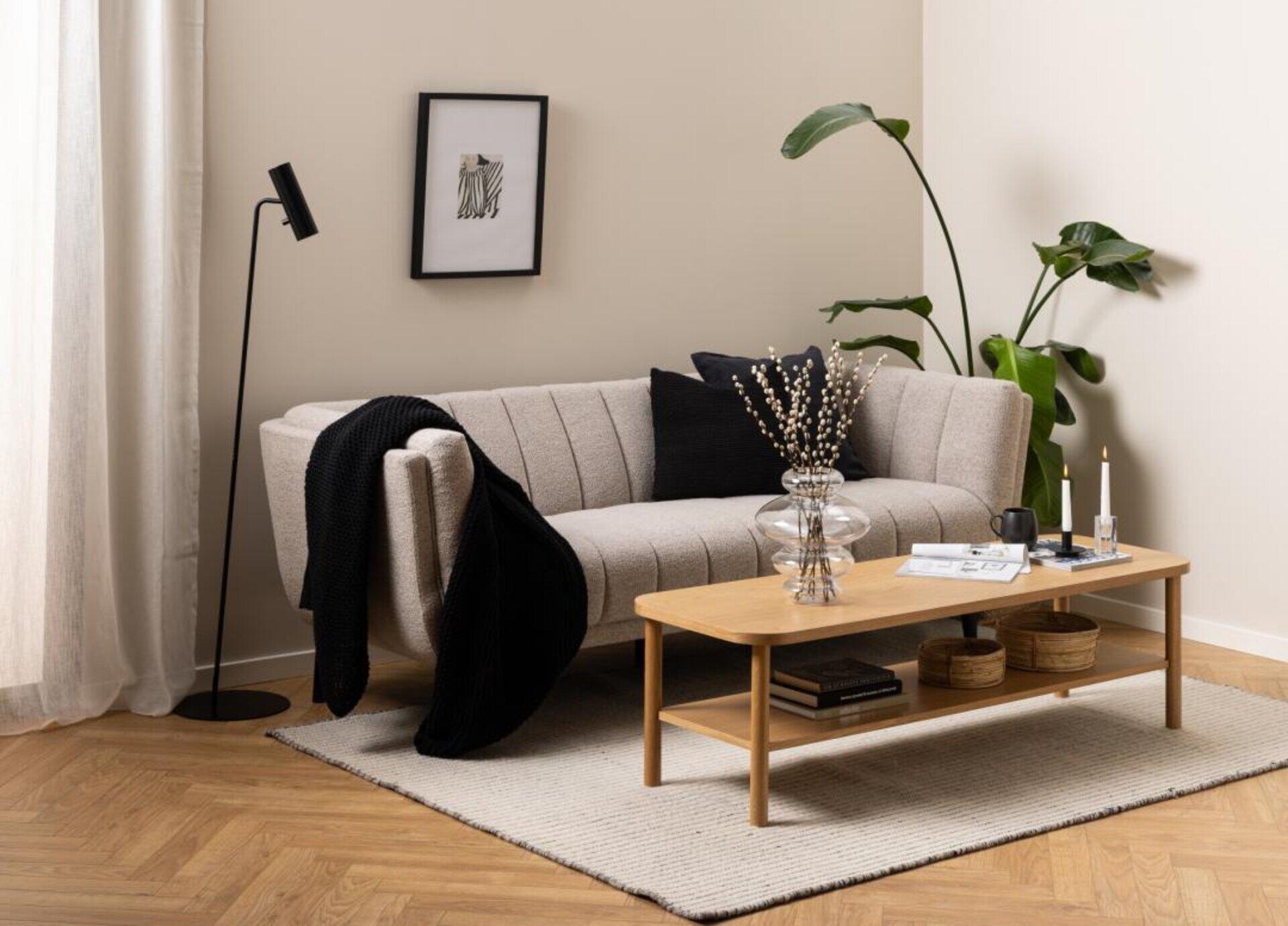 Tampa 3-Sitzer Couch im Wohnzimmerambiente mit Couchtisch und detailreicher Einrichtung aus leicht erhöhter Perspektive.