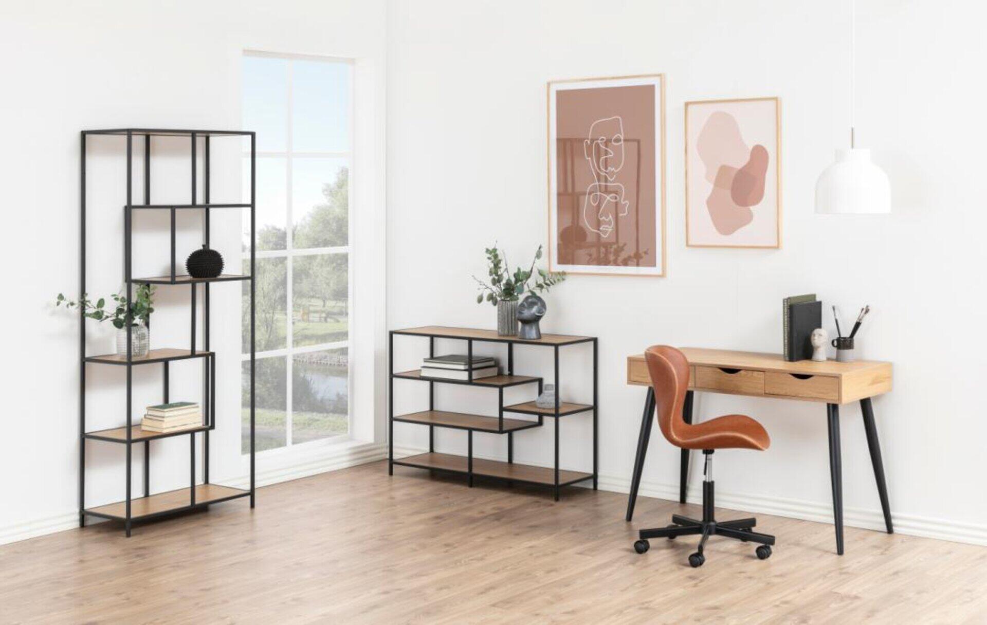 Regal Seaford mit asymmetrischem Design und vier Holzablagen, integriert in ein helles Wohnzimmer mit Blick ins Grüne.