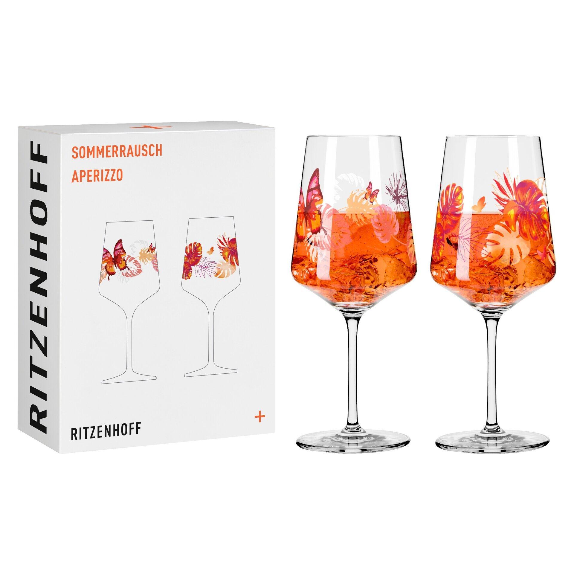 Zwei Aperitifgläser der Kollektion "Sommerausbruch Aperizzo" von Ritzenhoff, mit orangenem Getränk und Dekorationen versehen, in einer Geschenkbox präsentiert.