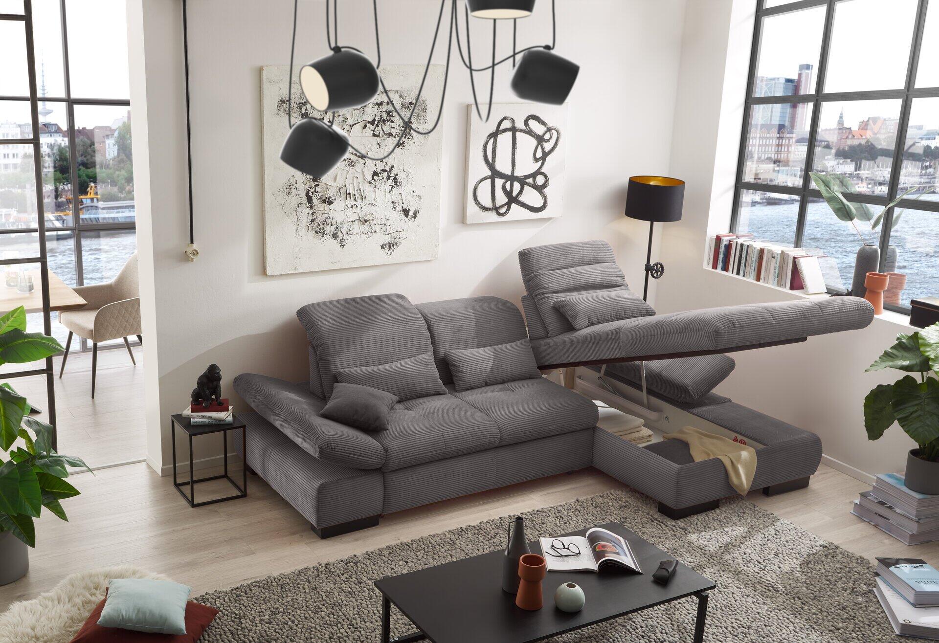 Eckcouch SO 4100 mit wellenförmiger Formgebung und integrierbarer ausziehbarer Liegefläche, abgebildet in einem modernen Wohnzimmer.