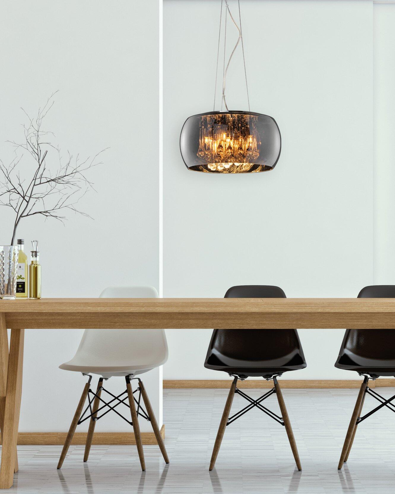 Pendelleuchte Vapore mit schwarzem Baldachin, die über einem Holztisch mit Dekoration hängend Licht nach unten reflektiert.