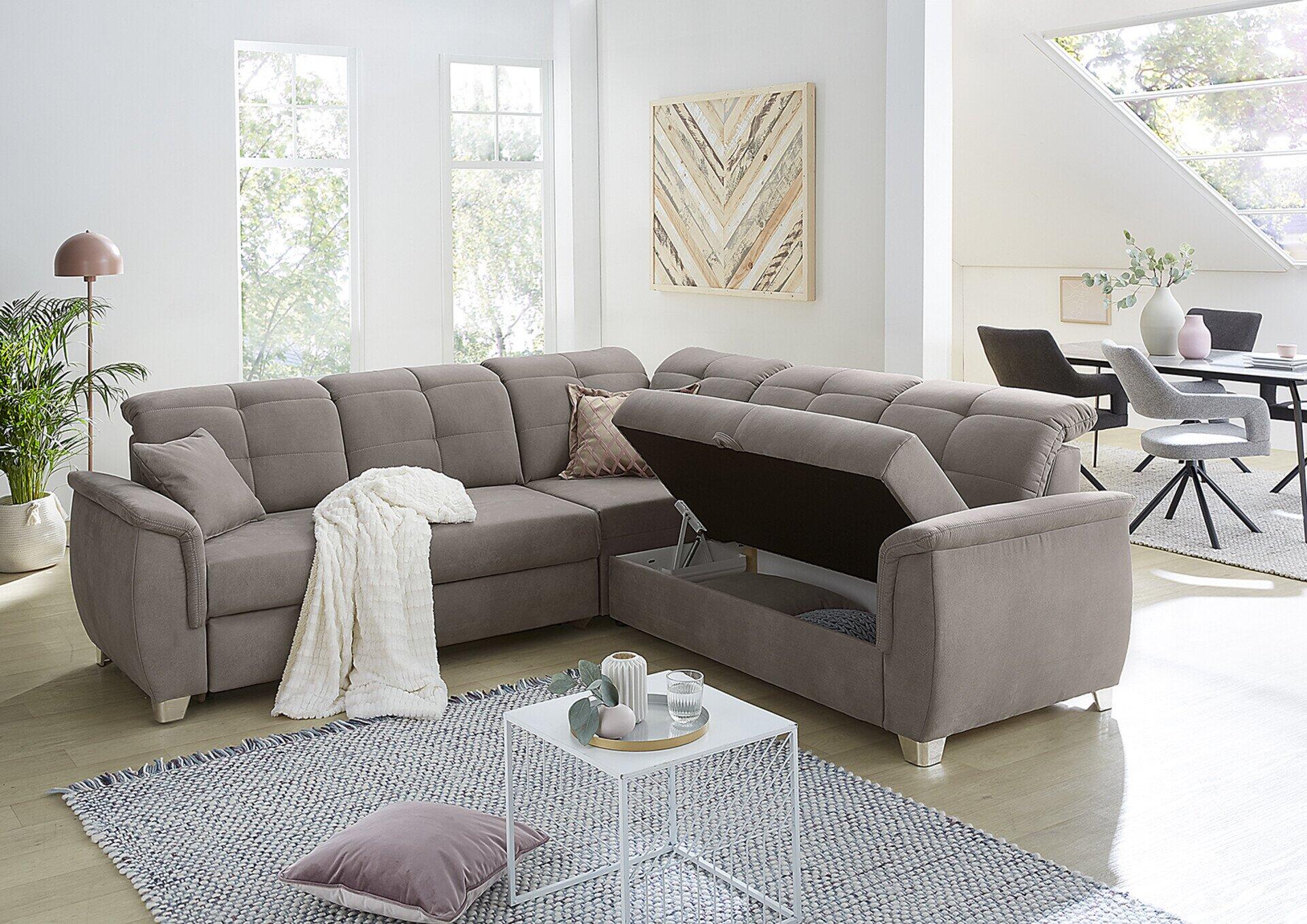 Wohnlandschaft Udine mit Relaxfunktion und verstellbaren Kopfstützen, abgebildet aus erhöhter Perspektive mit ausgeklappter Schlaffunktion und Dekoration.