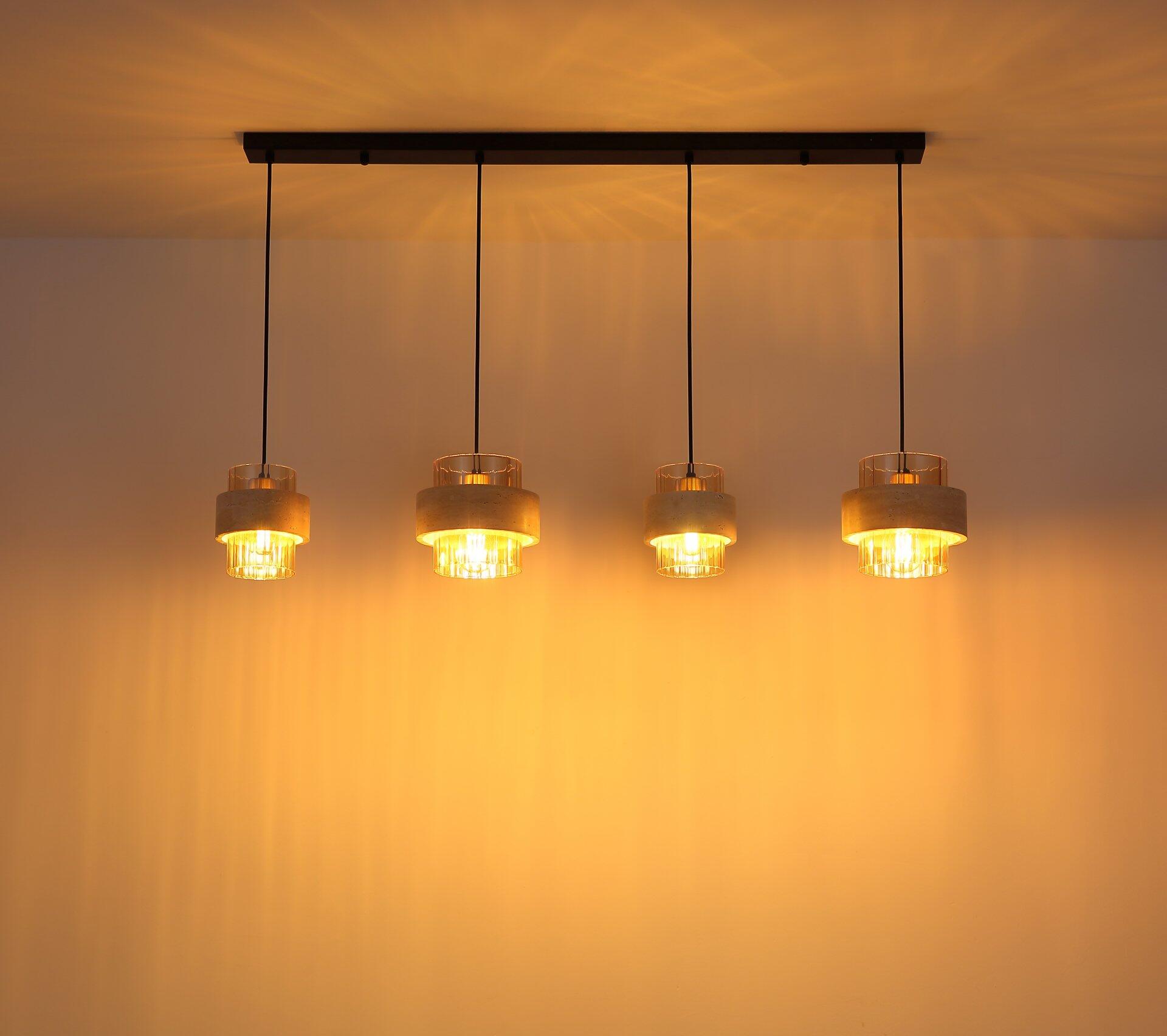 Pendelleuchte DAREN mit vier Lampenschirmen aus Holz und goldenem Material, die an einer schwarzen Stange hängen und einen warmen, indirekten Lichtschein erzeugen.