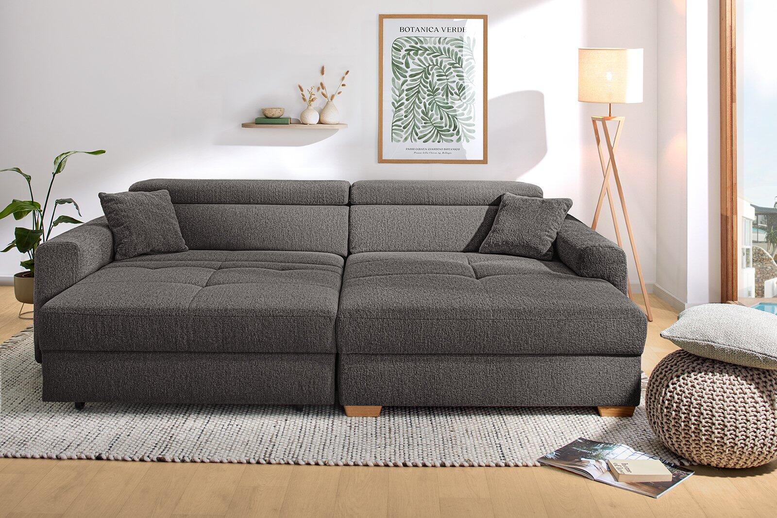 Moderne Wohnlandschaft "Slider" in grau mit Eichenfüßen, aus einer Frontalperspektive, zeigt die Eckanordnung mit Fußhocker und Schwenkfunktion links.