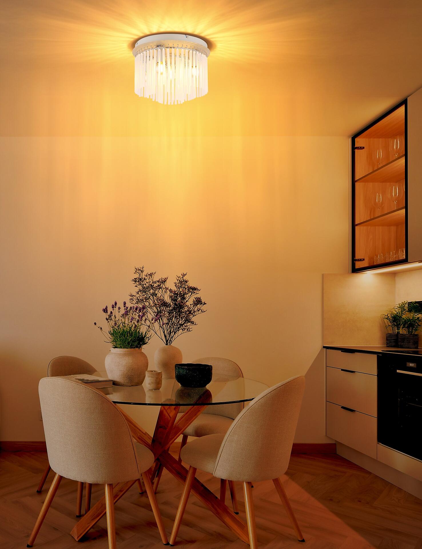 Deckenleuchte GORLEY mit kugelartigem, filigranem Design, die über einem Esstisch in einer modernen Essecke warmes Licht reflektiert.