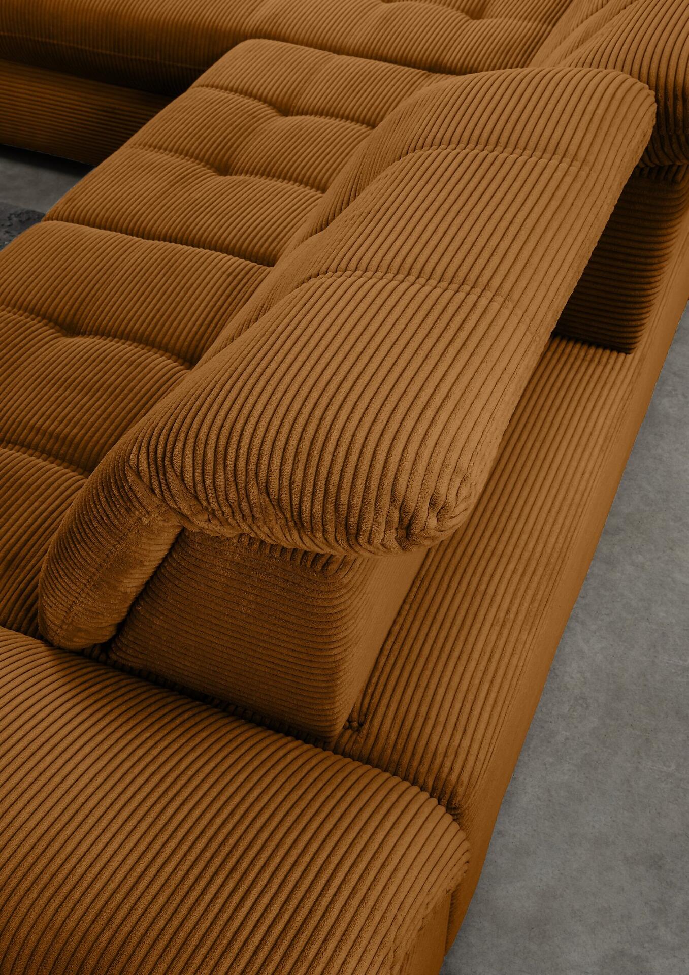 Cord-Ecksofa Rigatti mit detailliert gezeigter, modularen Rückenlehne und breiter Armlehne in warmem Orange-Ton.