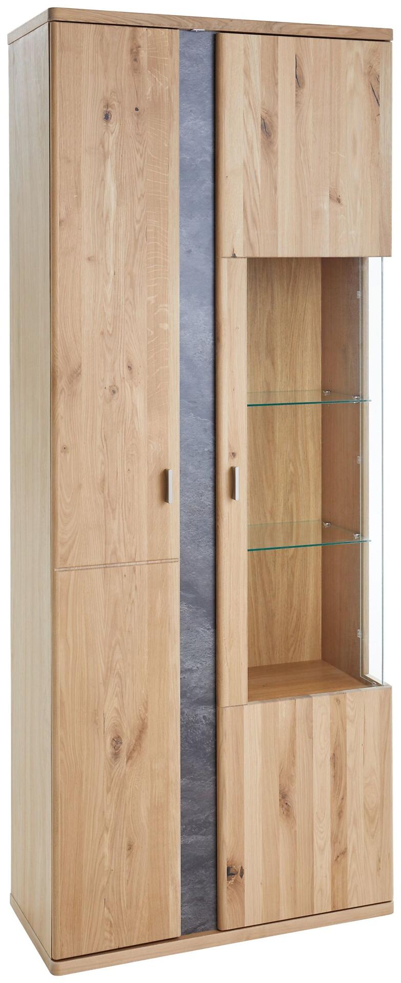 Vitrine Turego mit Front aus geölter Alteroche, zeigt eine frontale Ansicht mit linker Türfront aus massivem Holz und rechter Vitrinentür aus Glas, unterteilt durch einen dunkelgrauen Streifen und silberfarbenen Griffen.
