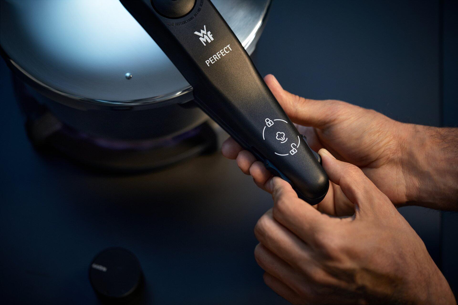 WMF Schnelltopf Perfect New: Detailaufnahme eines Smartphones, das zur Bedienung des Schnelltopfs gehalten wird.