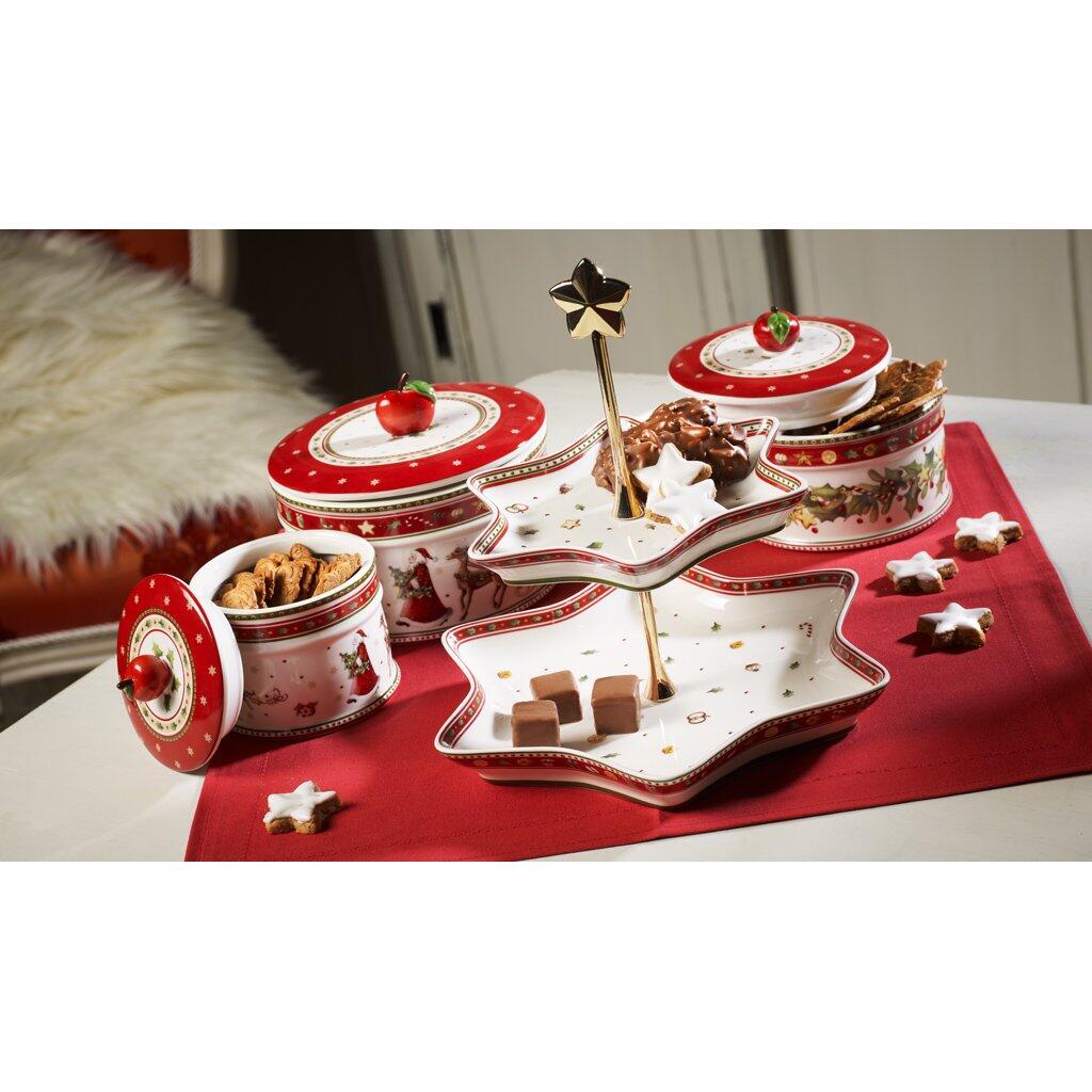 Weihnachtliche Gebäckdose aus der Winter Bakery Kollektion von Villeroy & Boch, abgebildet auf einer dekorativen Servierplatte mit Pralinen und Keksen, leicht von unten fotografiert, um die Details hervorzuheben.
