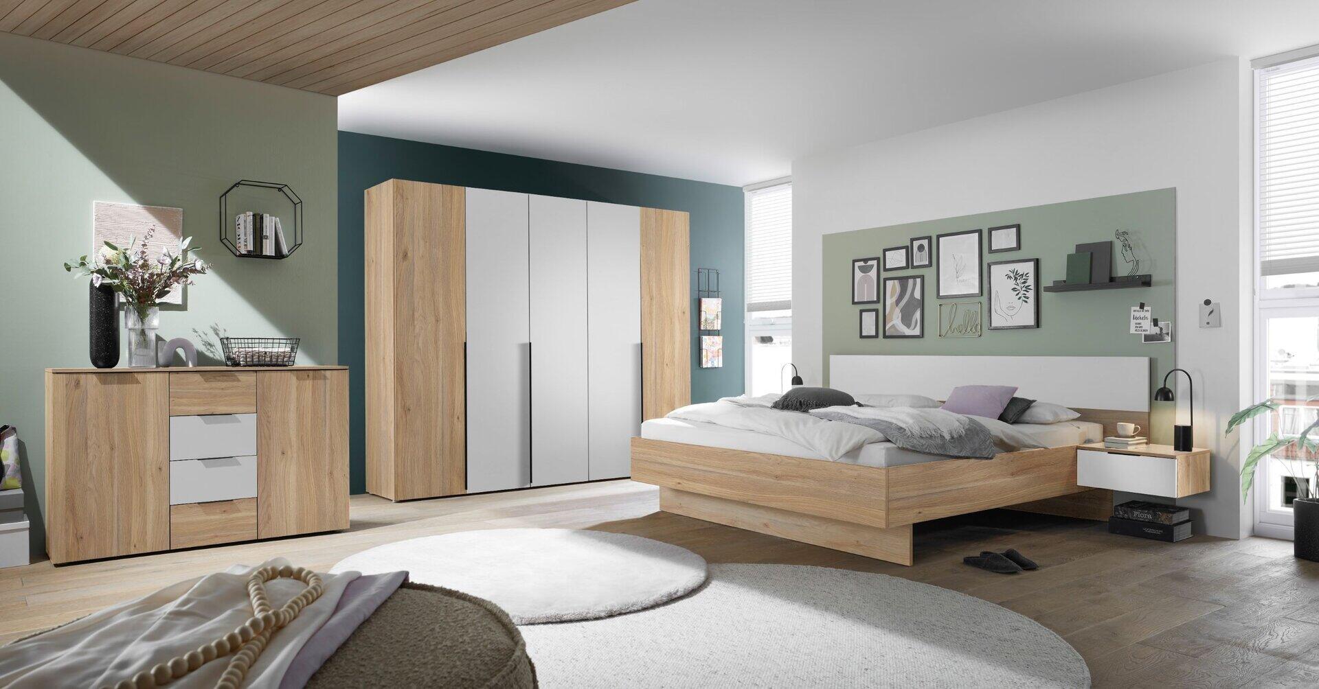 Schlafzimmer-Set Esra mit 5 Türen, Bettanlage und Nachtkommoden, aus der Vogelperspektive in einem hellen, modernen Zimmer zu sehen.