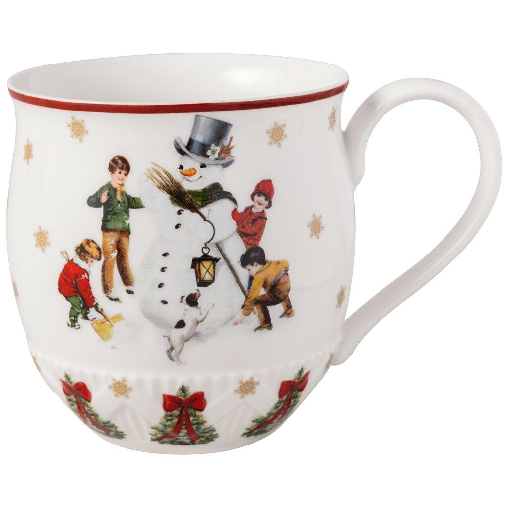 Weihnachtlicher Henkelbecher "Schneemann bauen" von Villeroy & Boch mit Illustration von Kindern, die einen Schneemann bauen, sowie einem roten Rand und einem weihnachtlichen Hintergrund.