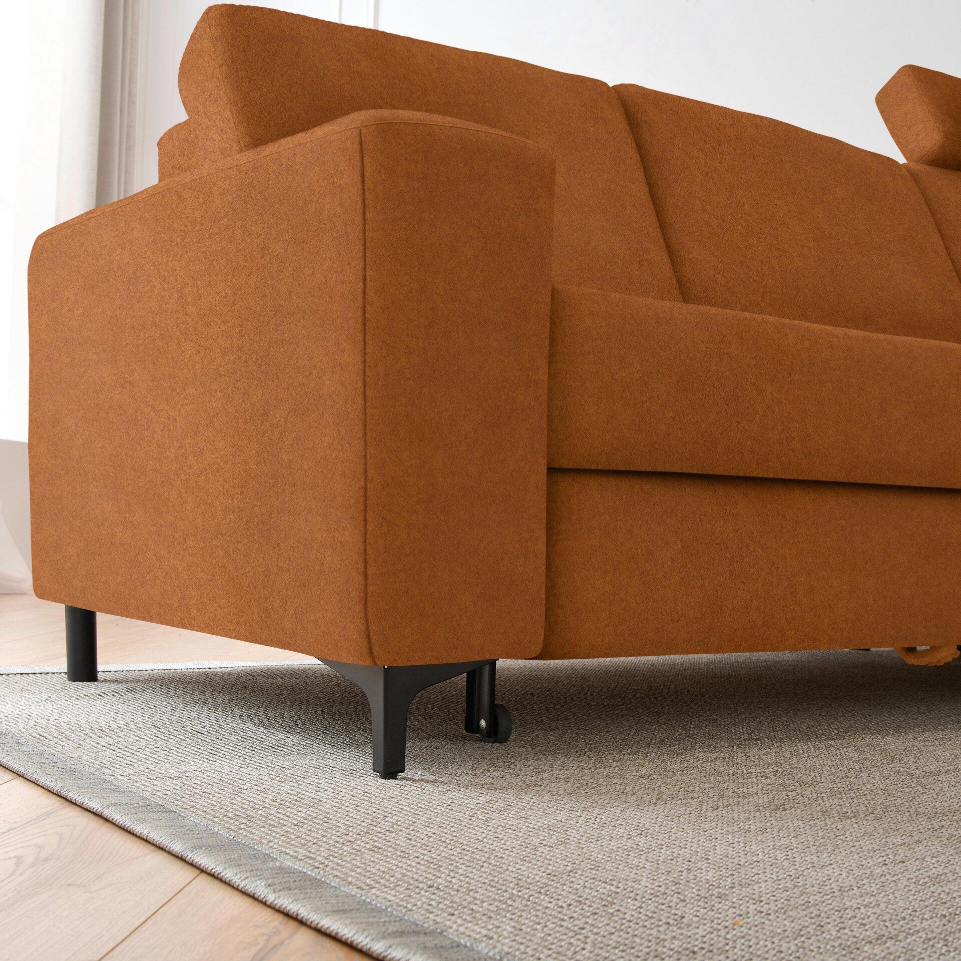 Ecksofa Balina mit schwarzen, konischen Metallfüßen und Rollen, Detailaufnahme der orangefarbenen Seitenlehne und des unteren Bereichs aus Seitenperspektive.