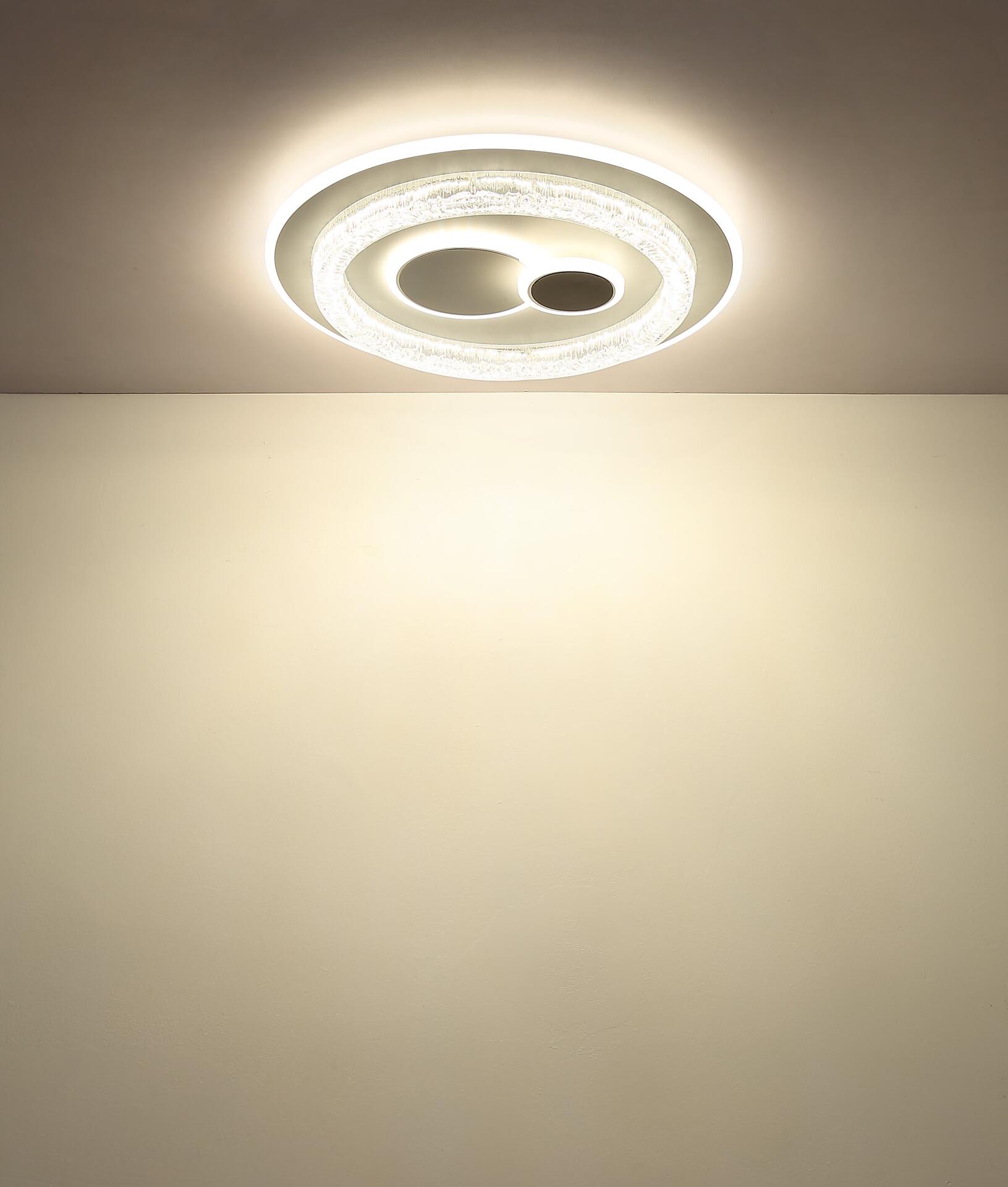 Deckenleuchte KRISWALL mit ringförmigen Elementen, die in mehreren Stufen dimmbar ist und eine Memoryfunktion besitzt, angebracht an einer hellen Wand.