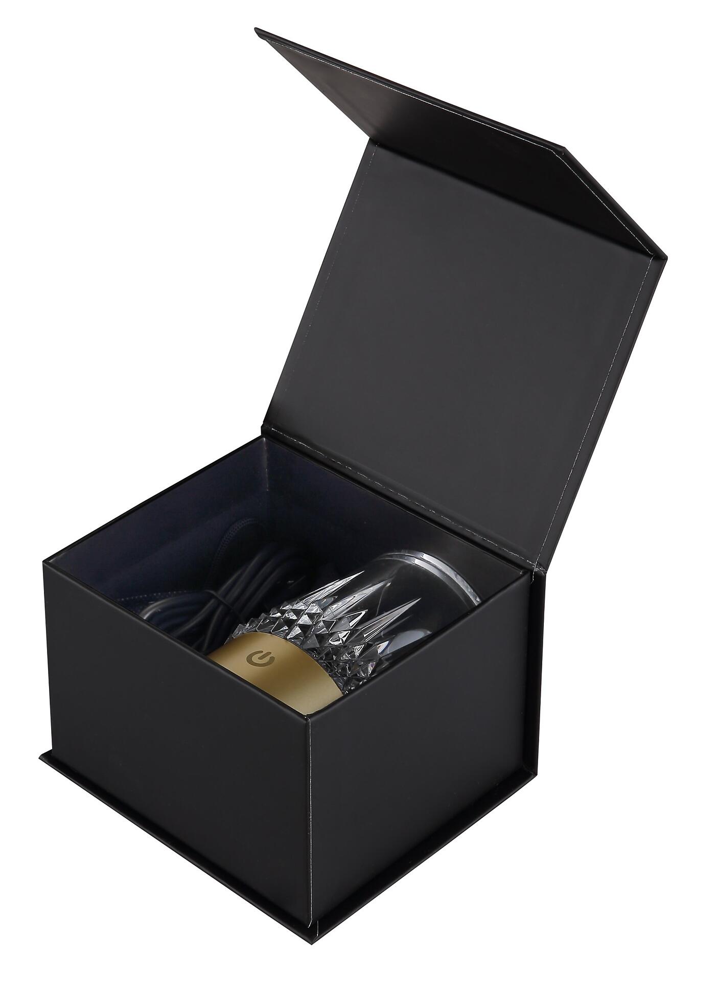 Geschenkbox mit schwarzem Kunststoffgehäuse, geöffnet, zeigt eine Tischleuchte auf goldenem Sockel mit Touchdimmer-Symbol.