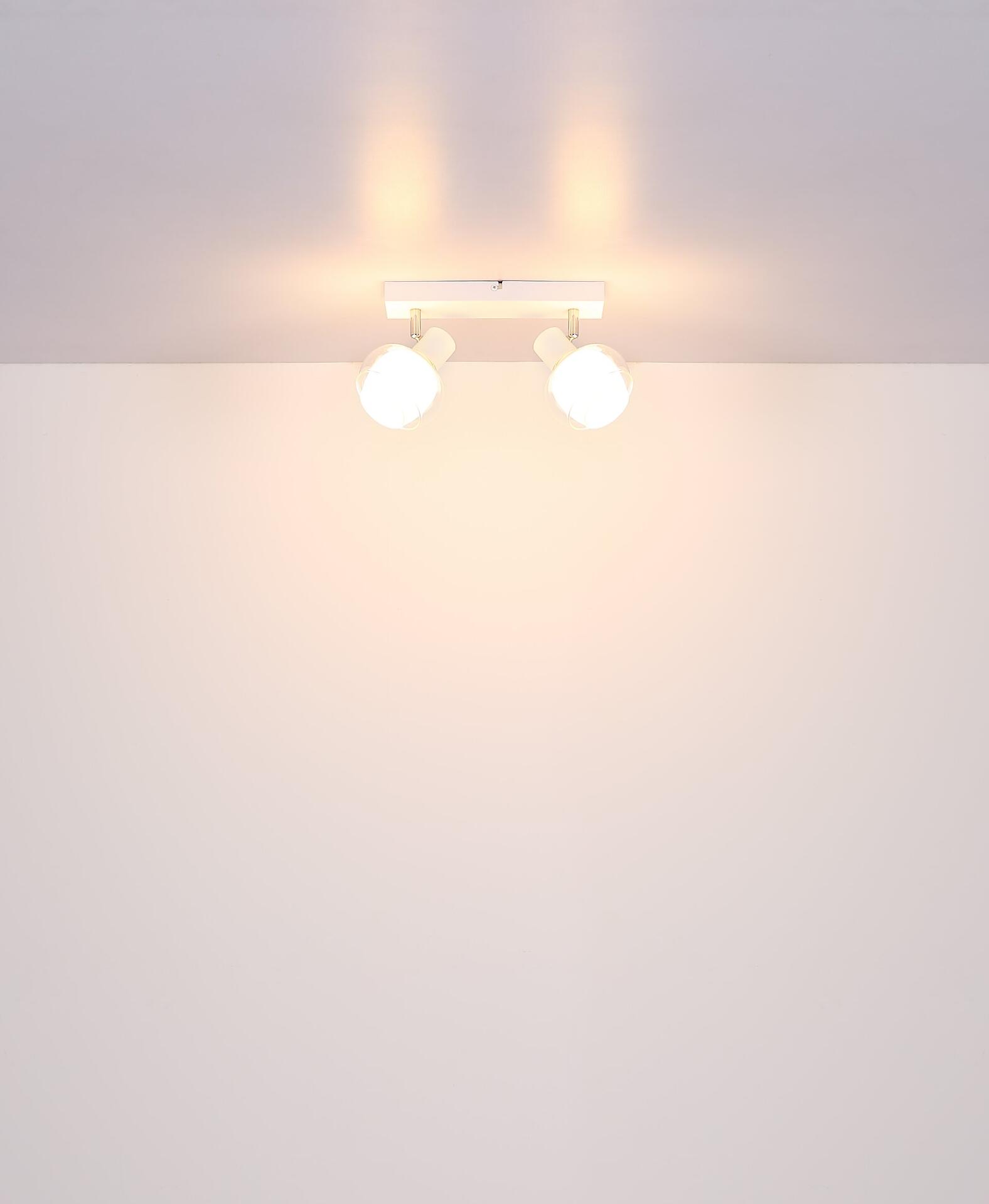 Moderne Tischleuchte TOKKI mit zwei weißen Lampenköpfen und horizontalem Arm, die indirektes, warmes Licht erzeugt.