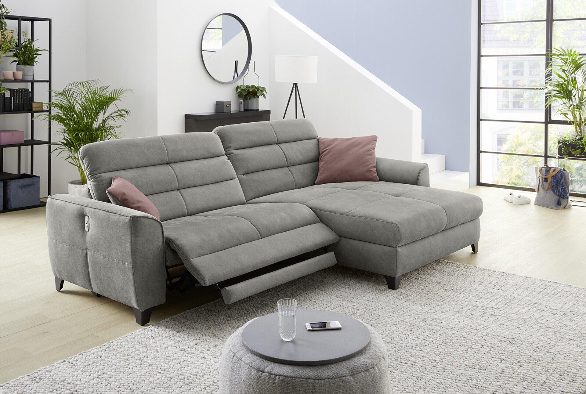Wohnlandschaft Double One mit ausgezogener Liegefläche und verstellbaren Kopfstützen, dargestellt in einer erhöhten Perspektive in einem hellen Wohnzimmer.