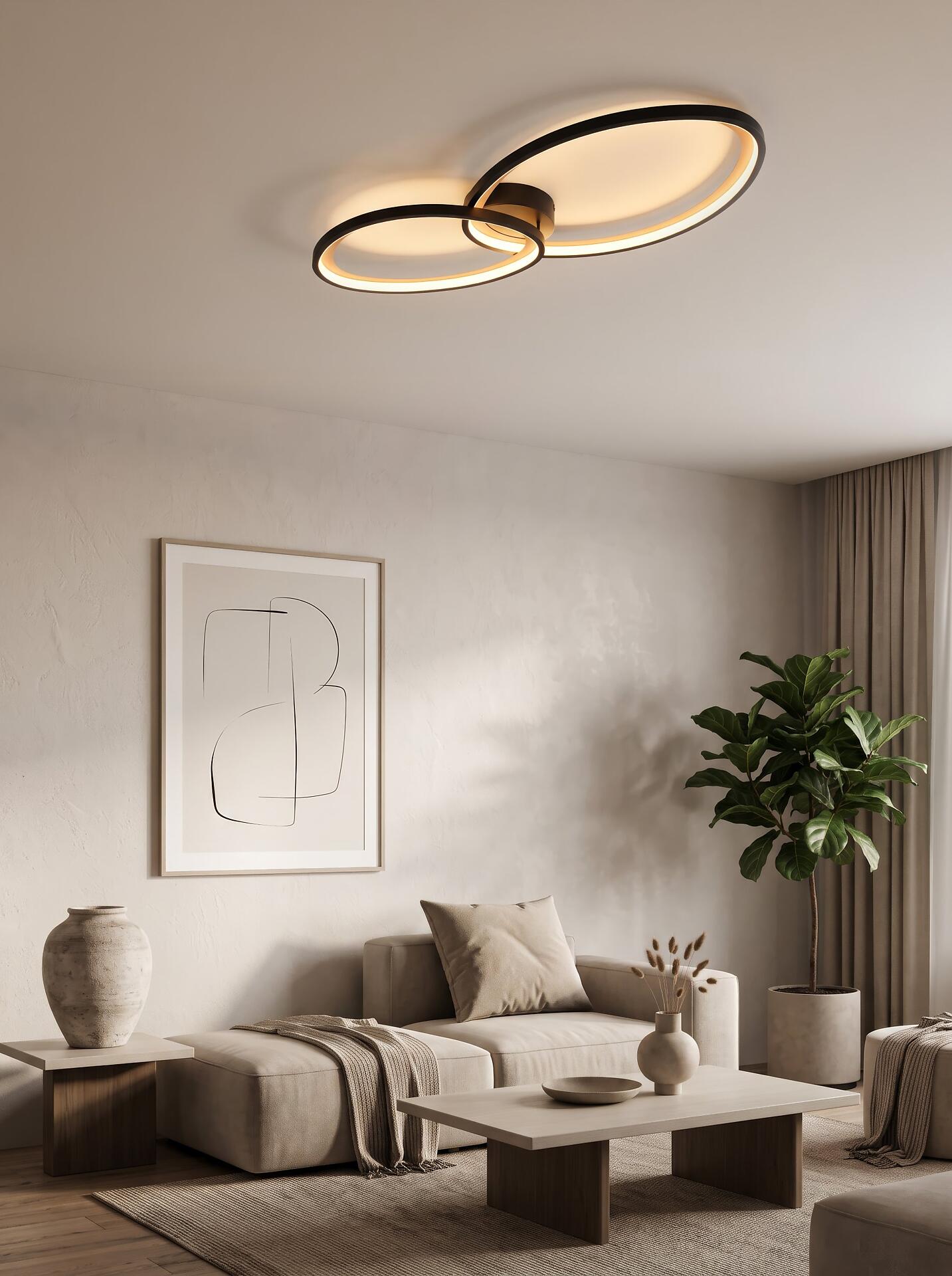 Moderne Deckenleuchte Sivo mit ellipsenförmigen LED-Ringen, die aus einer leicht erhöhten Perspektive in einem stilvollen Wohnzimmerambiente gezeigt wird.