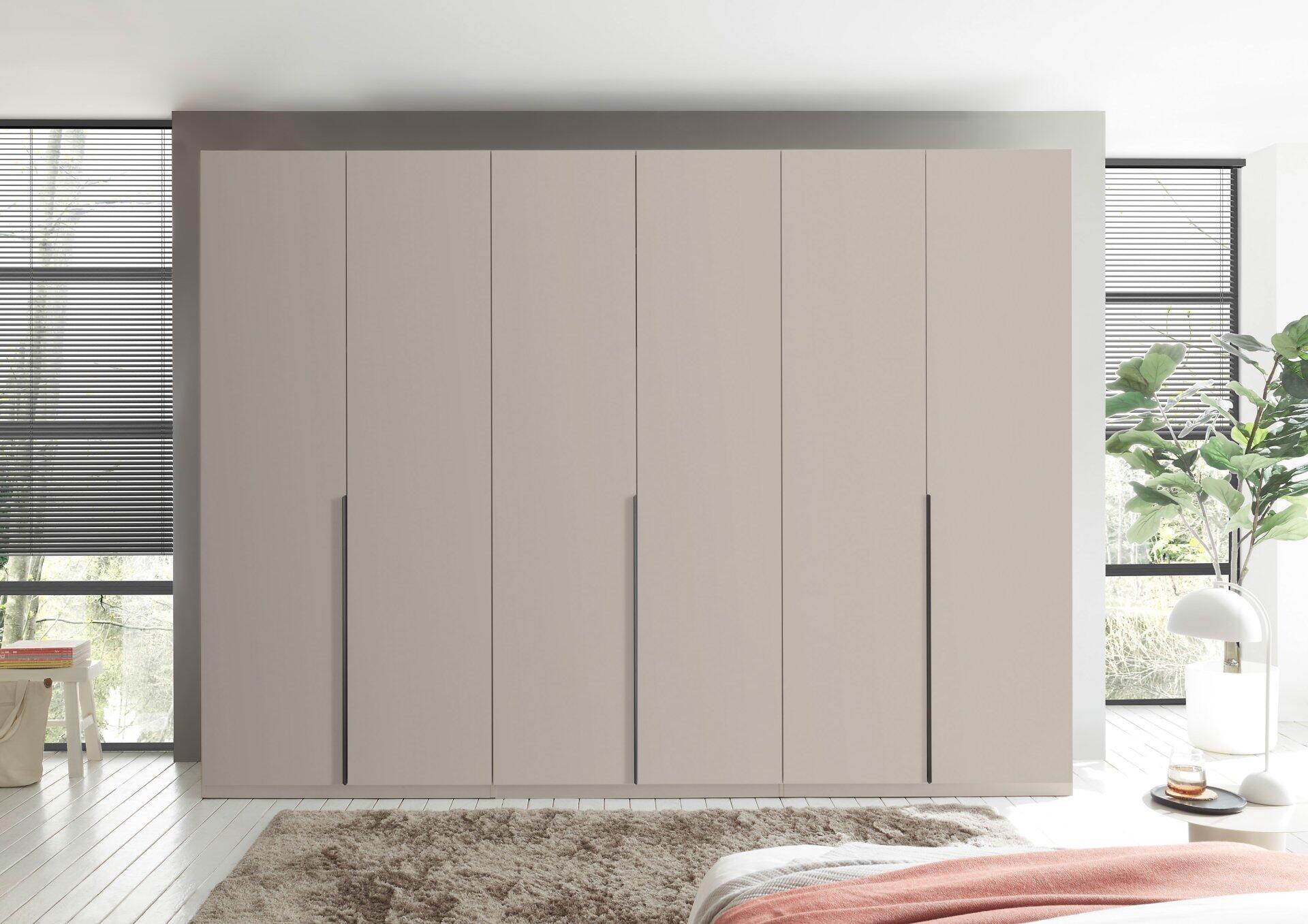 Kleiderschrank Camoleo mit sechs Türen, bündig an der Wand platziert, und einem Spiegel an der linken Türinnenseite.