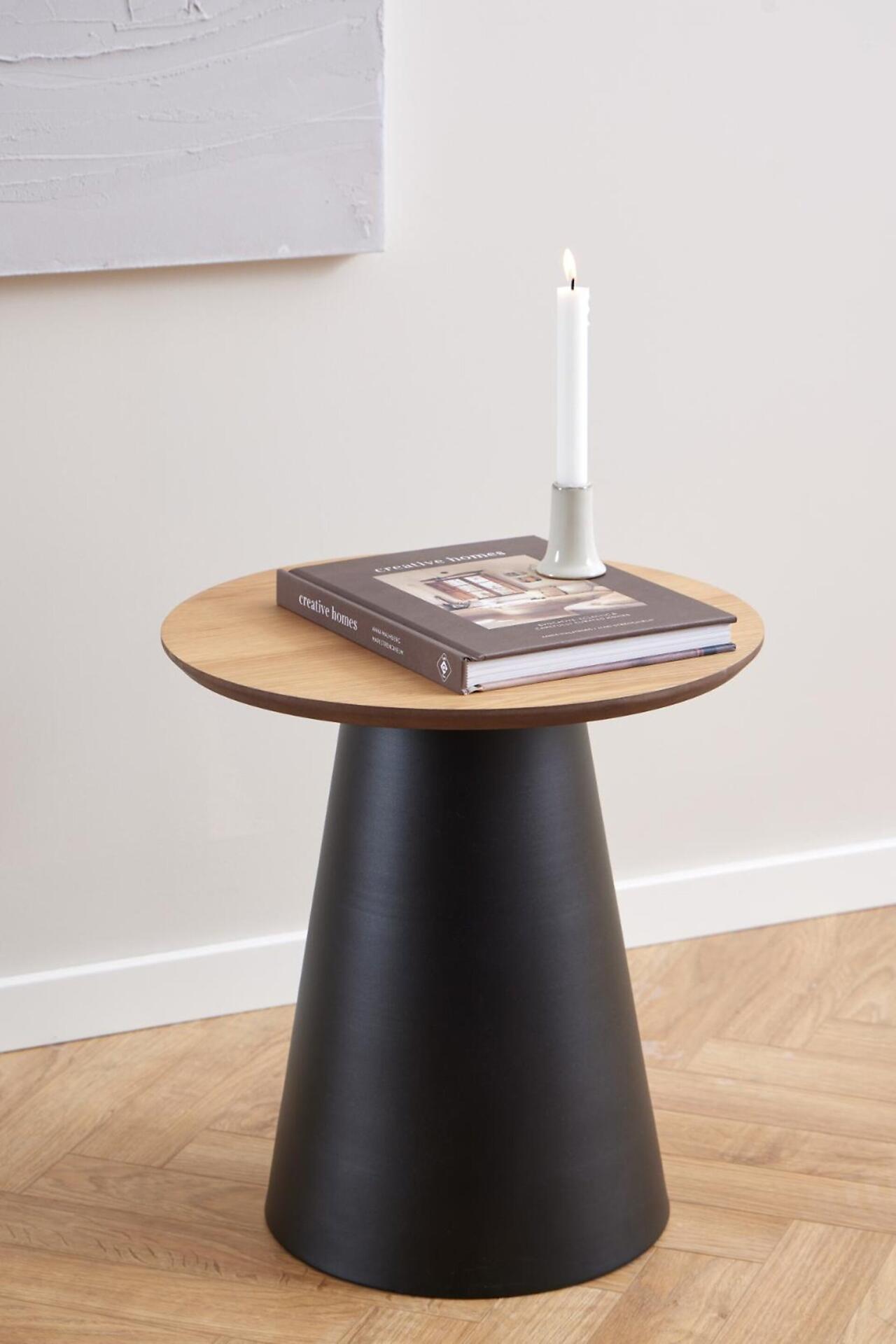 Beistelltisch Soli mit konischer Form, heller Holzplatte mit Maserung und schwarzem Fuß, dekoriert mit Buch und Kerze.