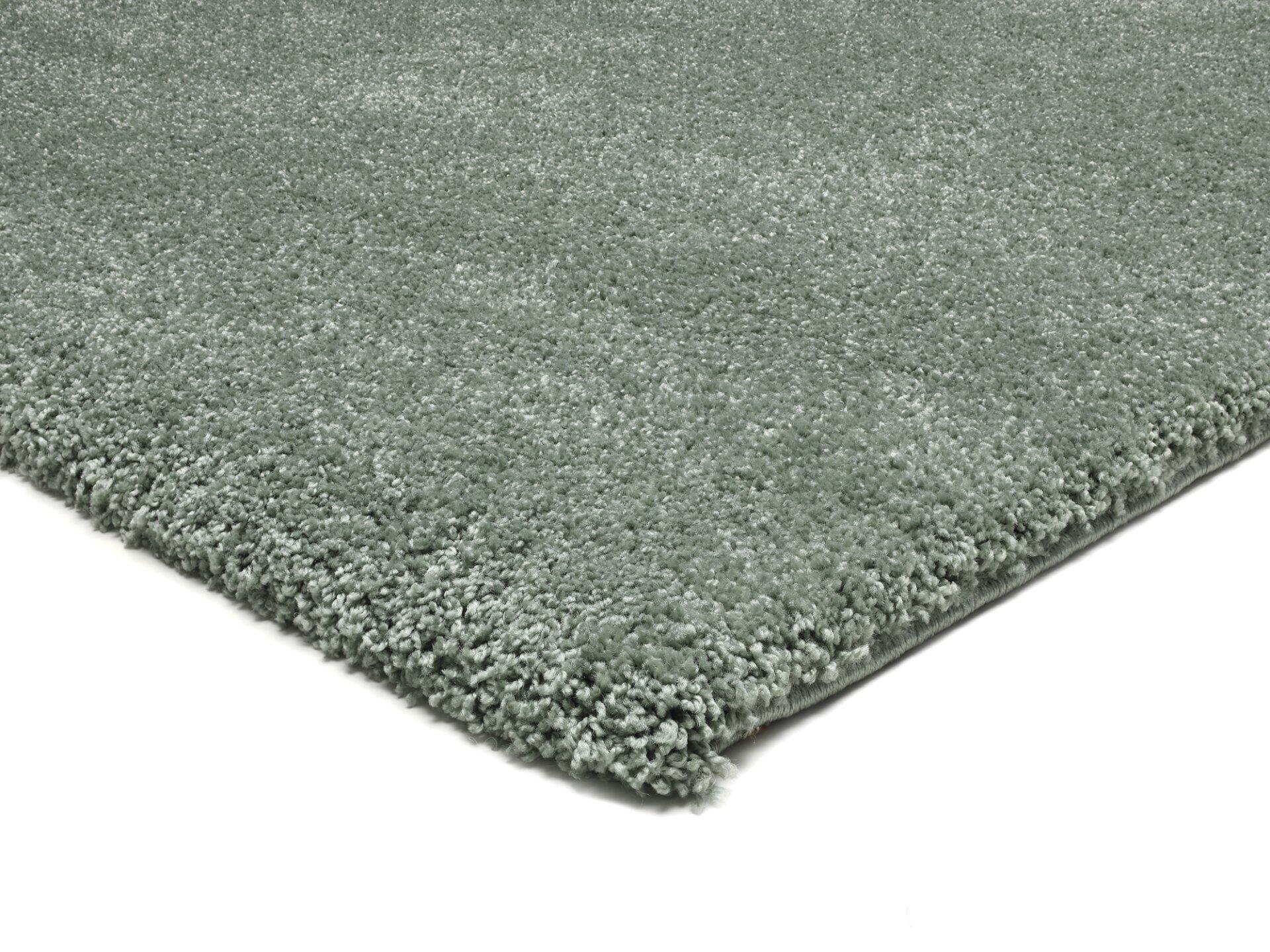 Detailaufnahme des Maschinenwebteppichs Erdara mit kurzem, flauschigem Flor und einer diagonalen Perspektive, die die unregelmäßigen Kanten und die helle Farbgebung betont.
