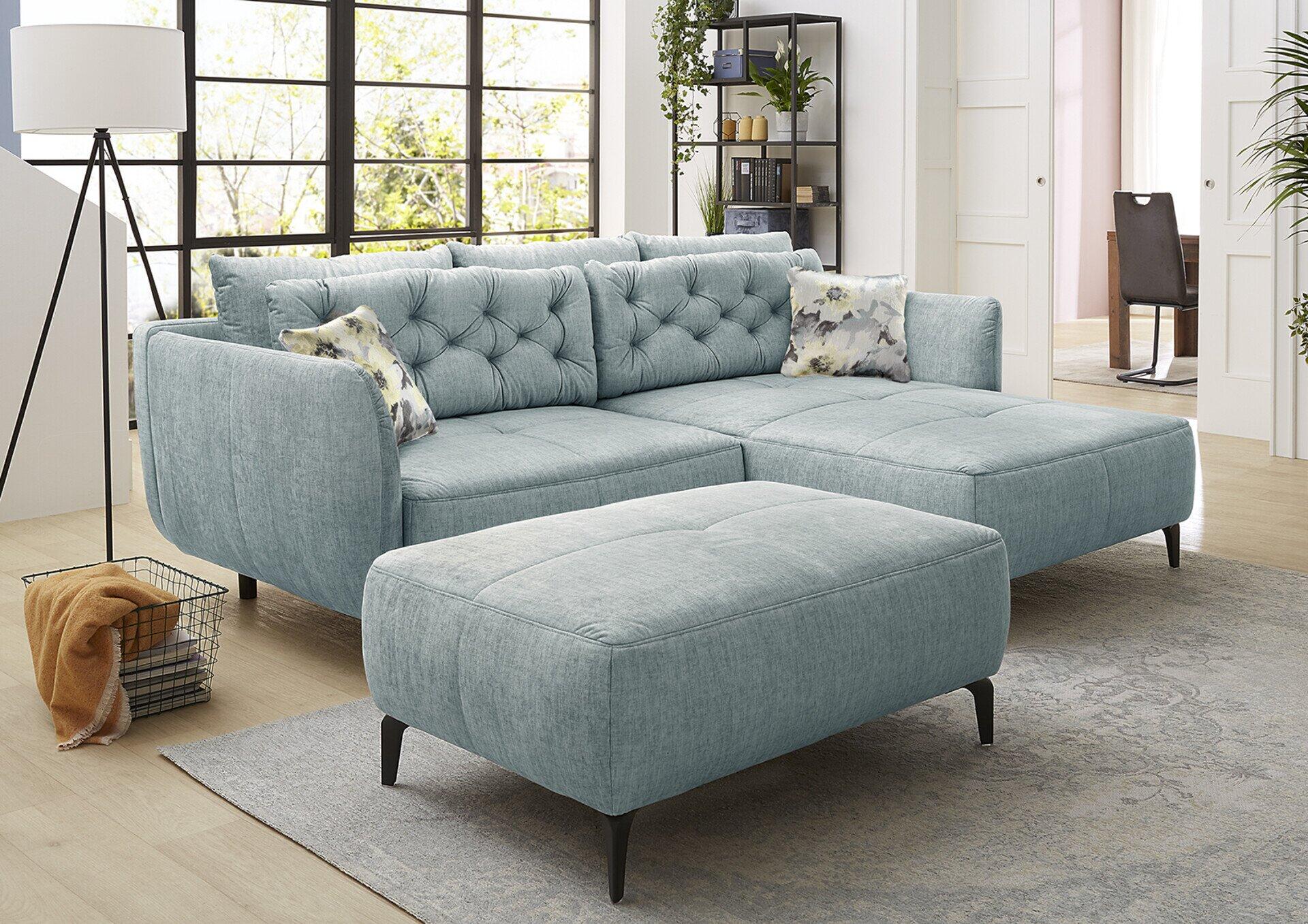 Wohnlandschaft Salo in hellblau mit Ottomane, Knopfheftungen und floralen Kissen, aus erhöhter Perspektive im hellen Wohnzimmer.