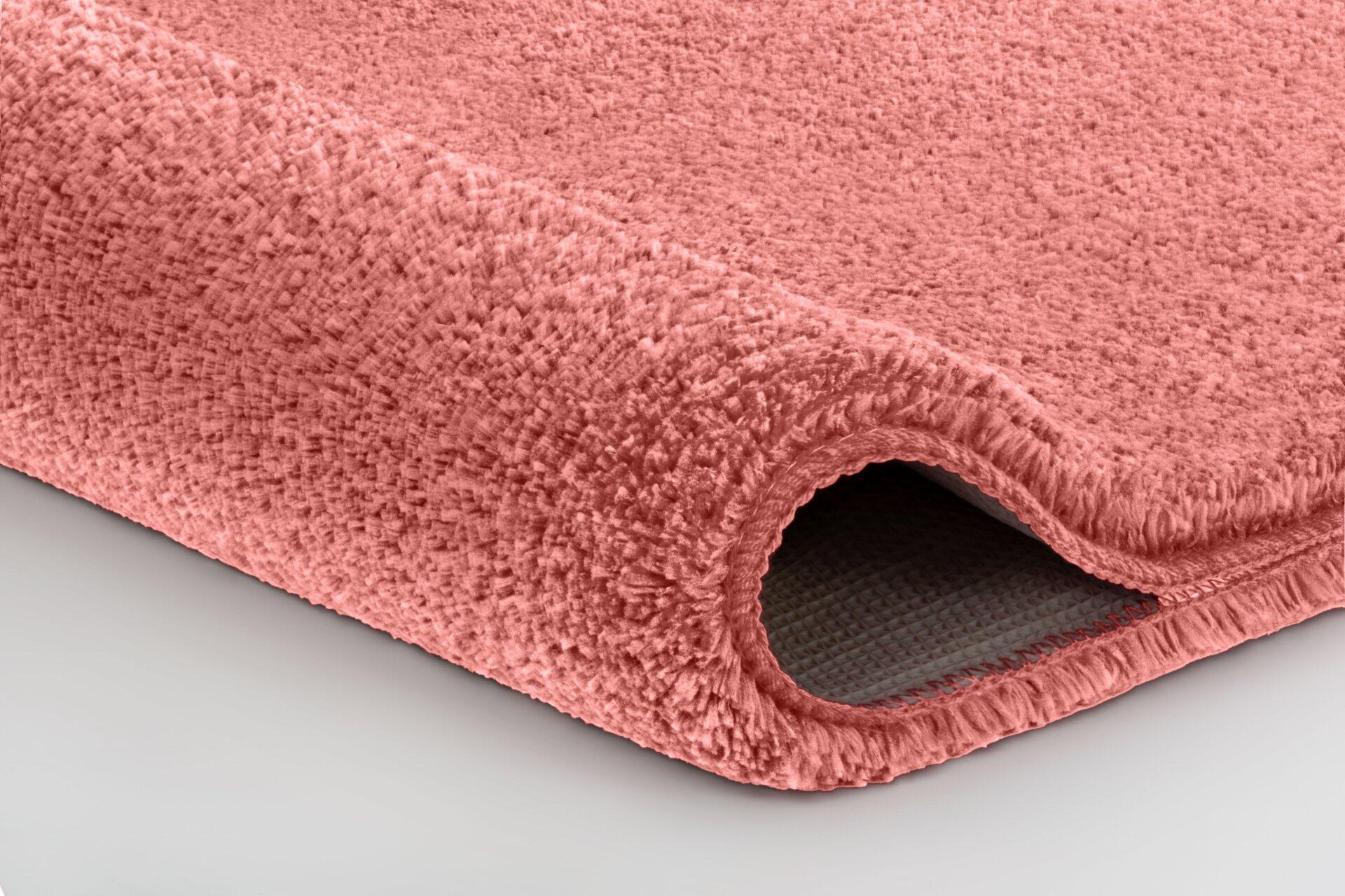 Detailaufnahme des Badteppichs Meadow mit flauschigem, hochflorigem Gewebe in Hellrosa und rutschfester Unterseite.