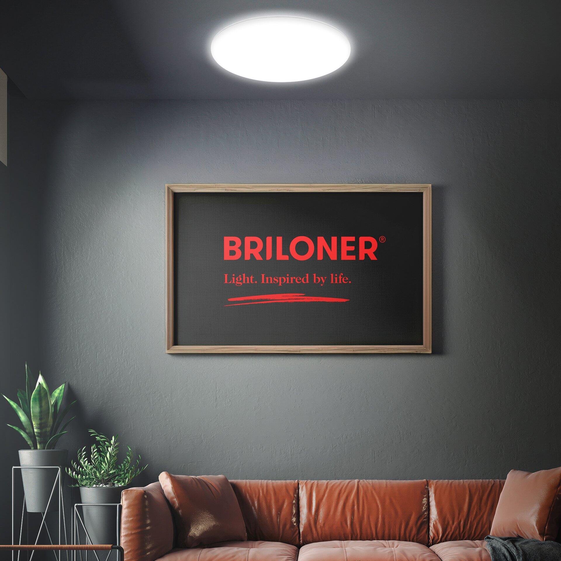 Deckenleuchte Rowny BRILO, LED-Wand- und Deckenleuchte, die aus einer leicht erhöhten Perspektive in einem stilvollen Wohnzimmerambiente integriert ist und helles, diffuses Licht abgibt.